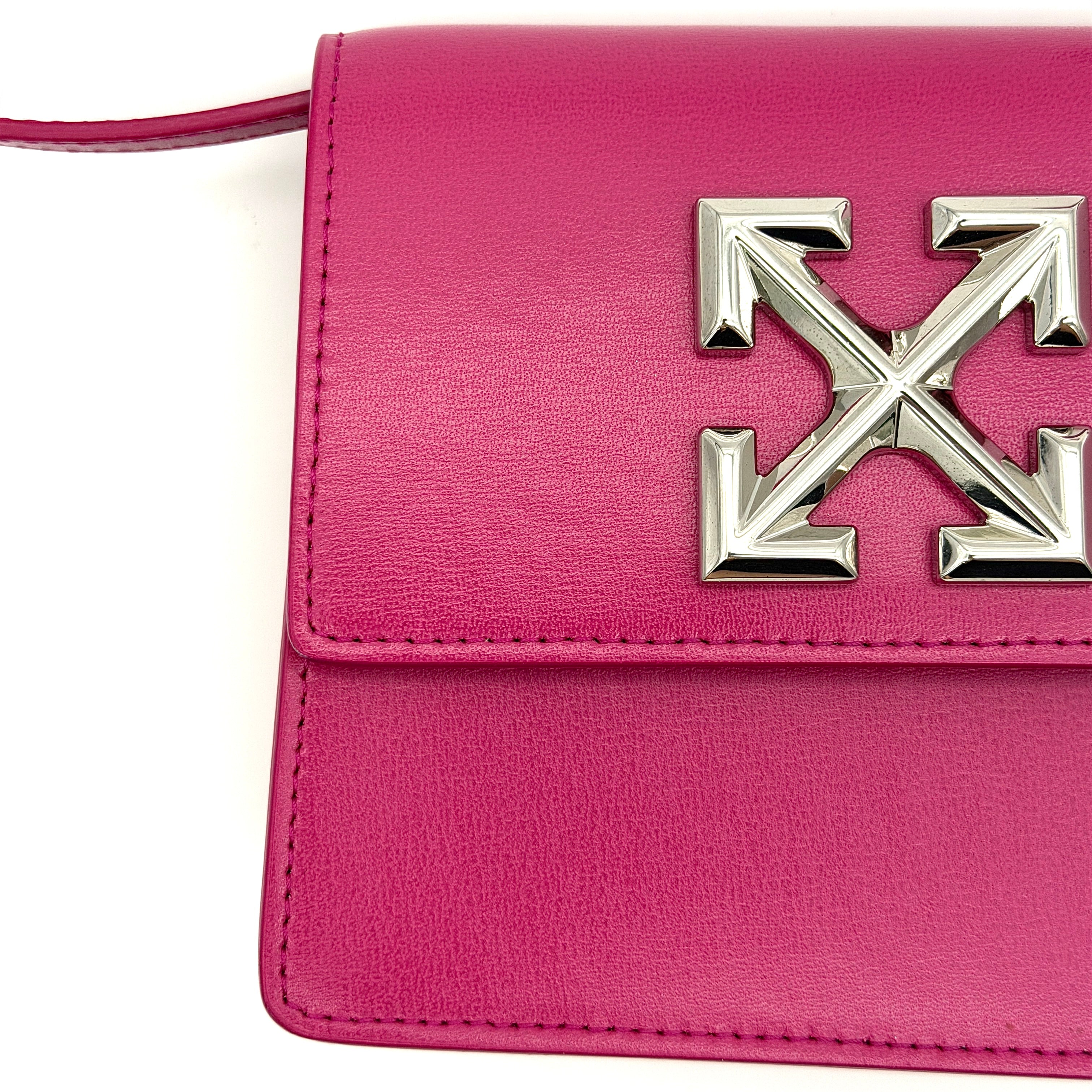 Off-White Jitney 0.7 Crossbody Bag in pink leather with silver-tone arrow logo and adjustable strap, shown against a white background.