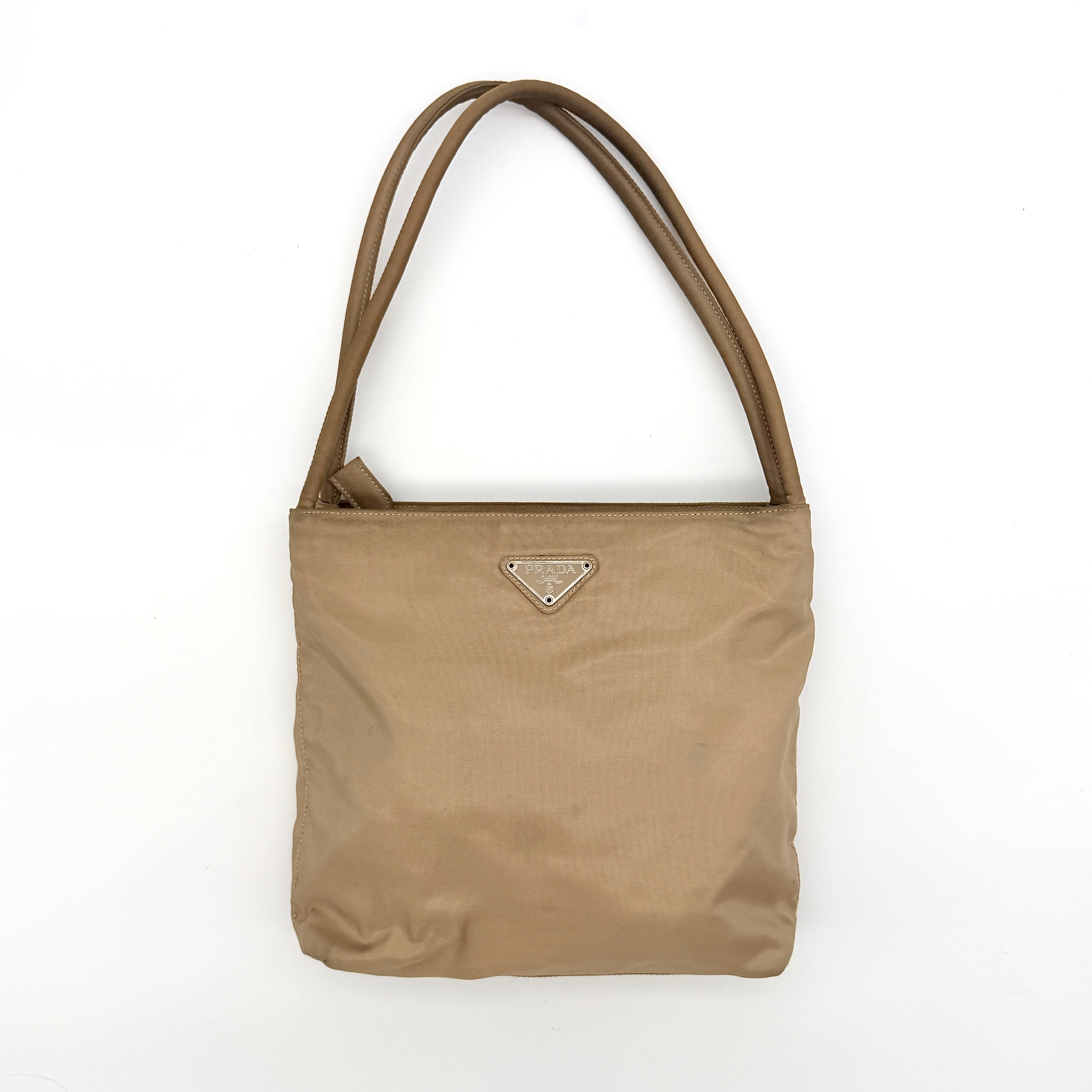 Prada Tessuto nylon tote bag in beige with silver-tone logo plaque and dual handles.