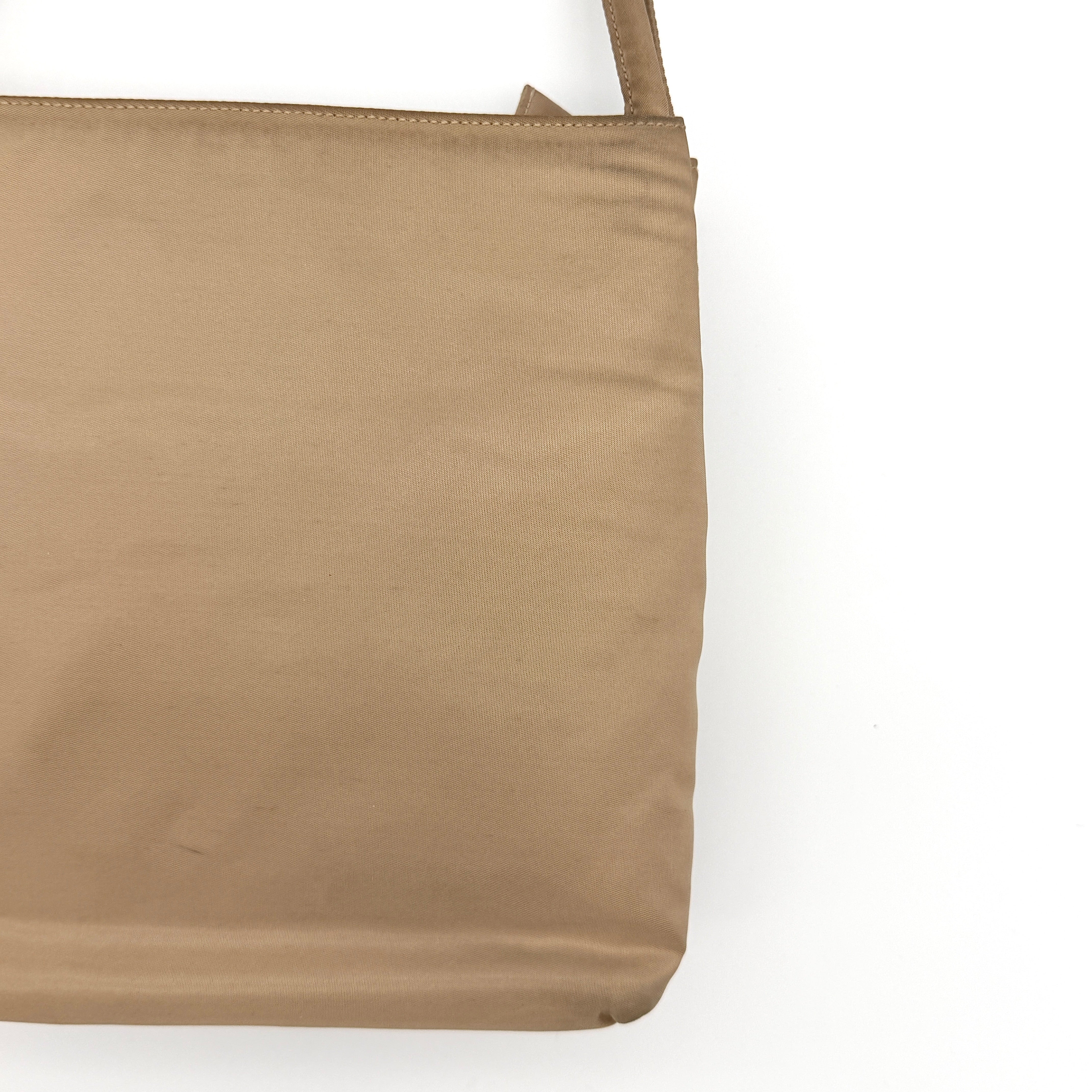 Prada Tessuto nylon tote bag in beige with silver-tone logo plaque and dual handles.