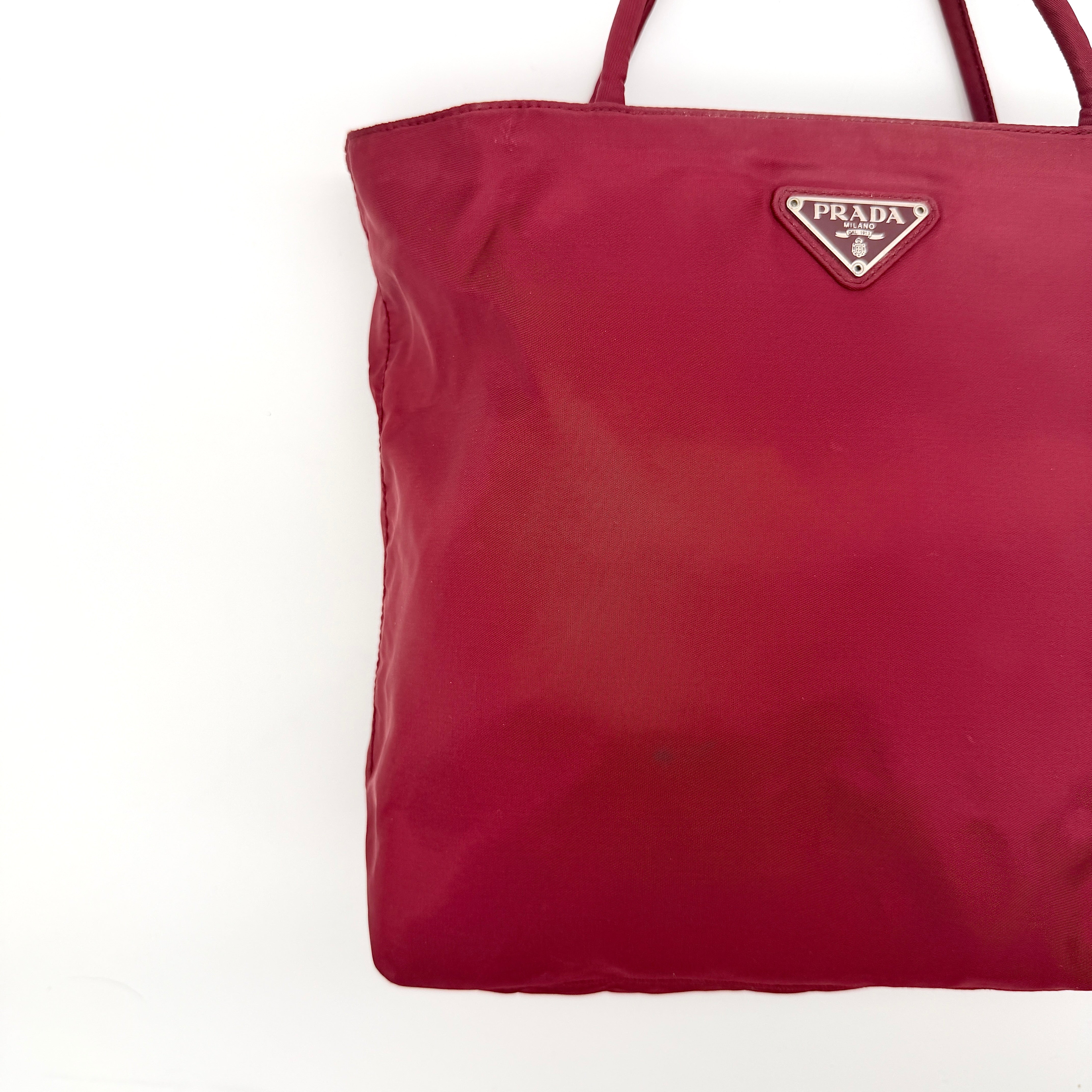 Red Prada Tessuto Nylon Tote Bag with double shoulder straps and classic enamel logo, displayed against a white background.