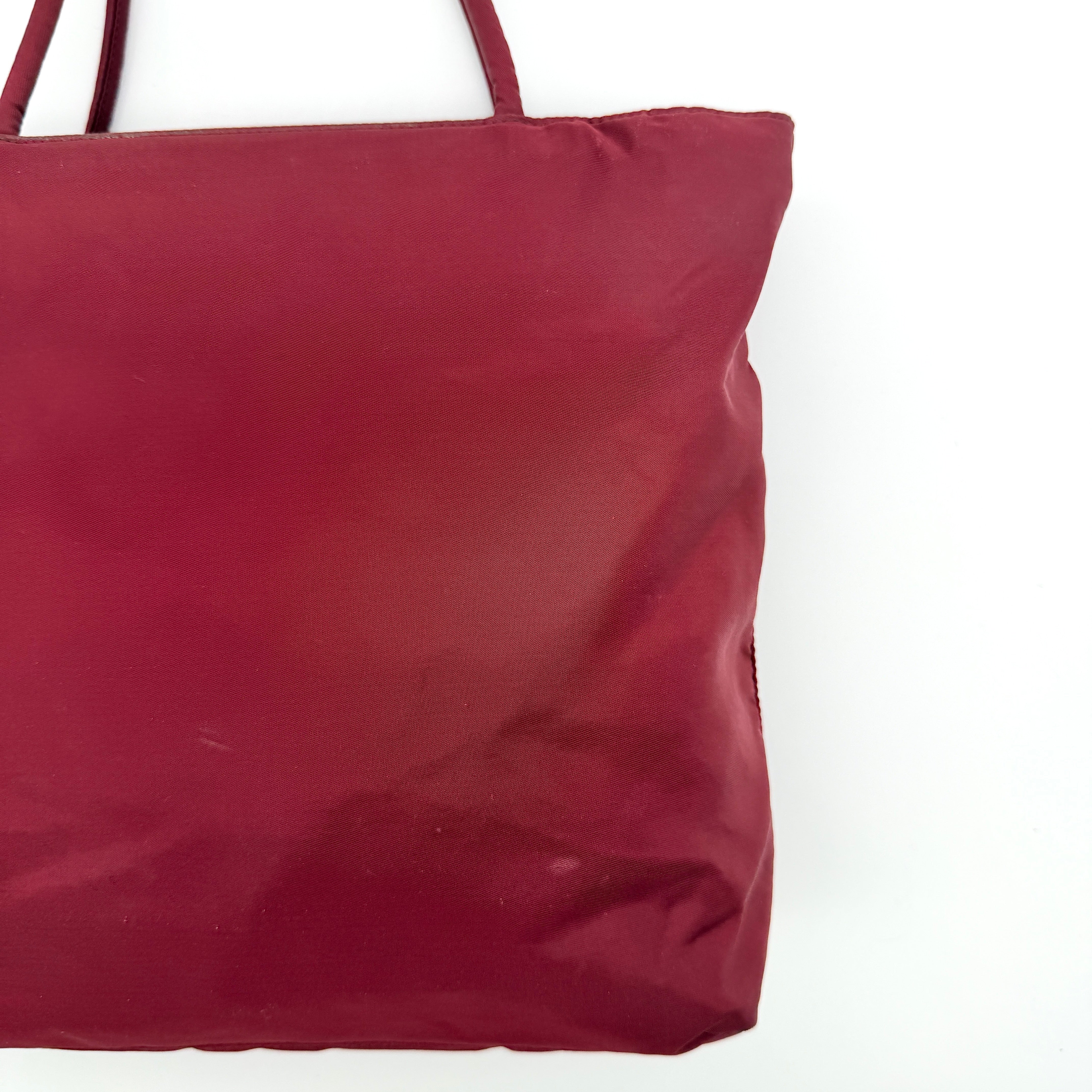 Red Prada Tessuto Nylon Tote Bag with double shoulder straps and classic enamel logo, displayed against a white background.