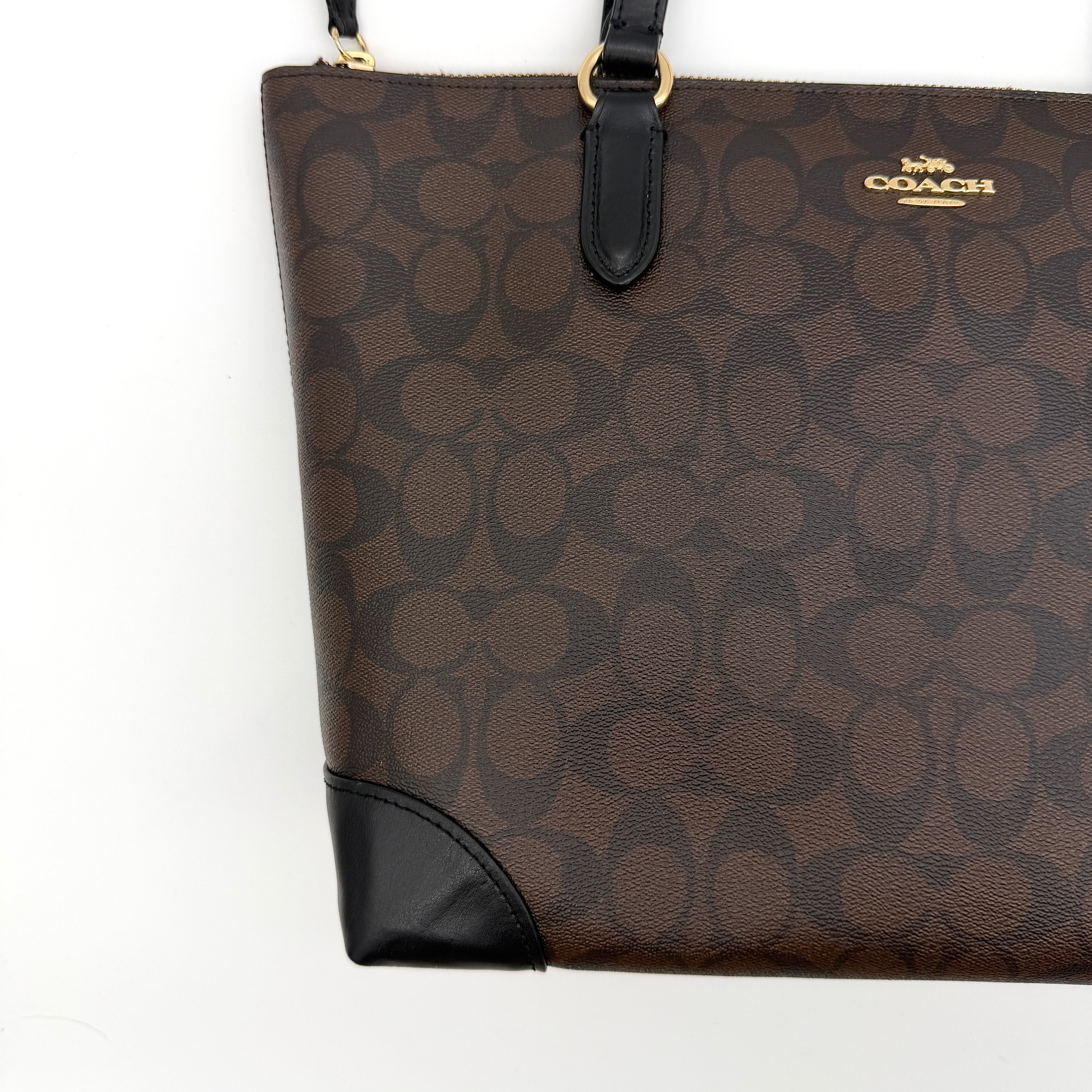 Coach Signature Zip Top Tote Bag in brown and black canvas with leather trim and gold-tone hardware.