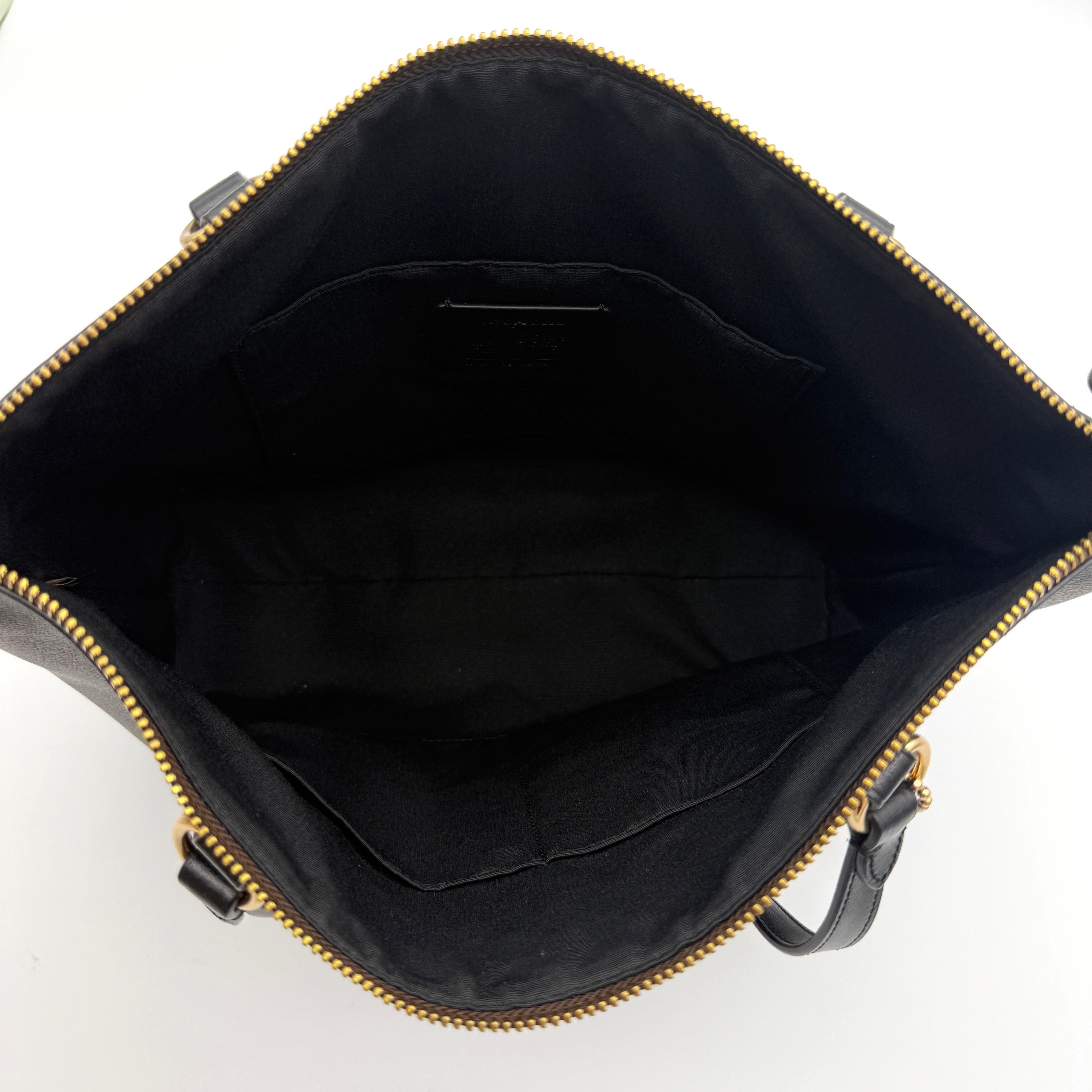 Coach Signature Zip Top Tote Bag in brown and black canvas with leather trim and gold-tone hardware.