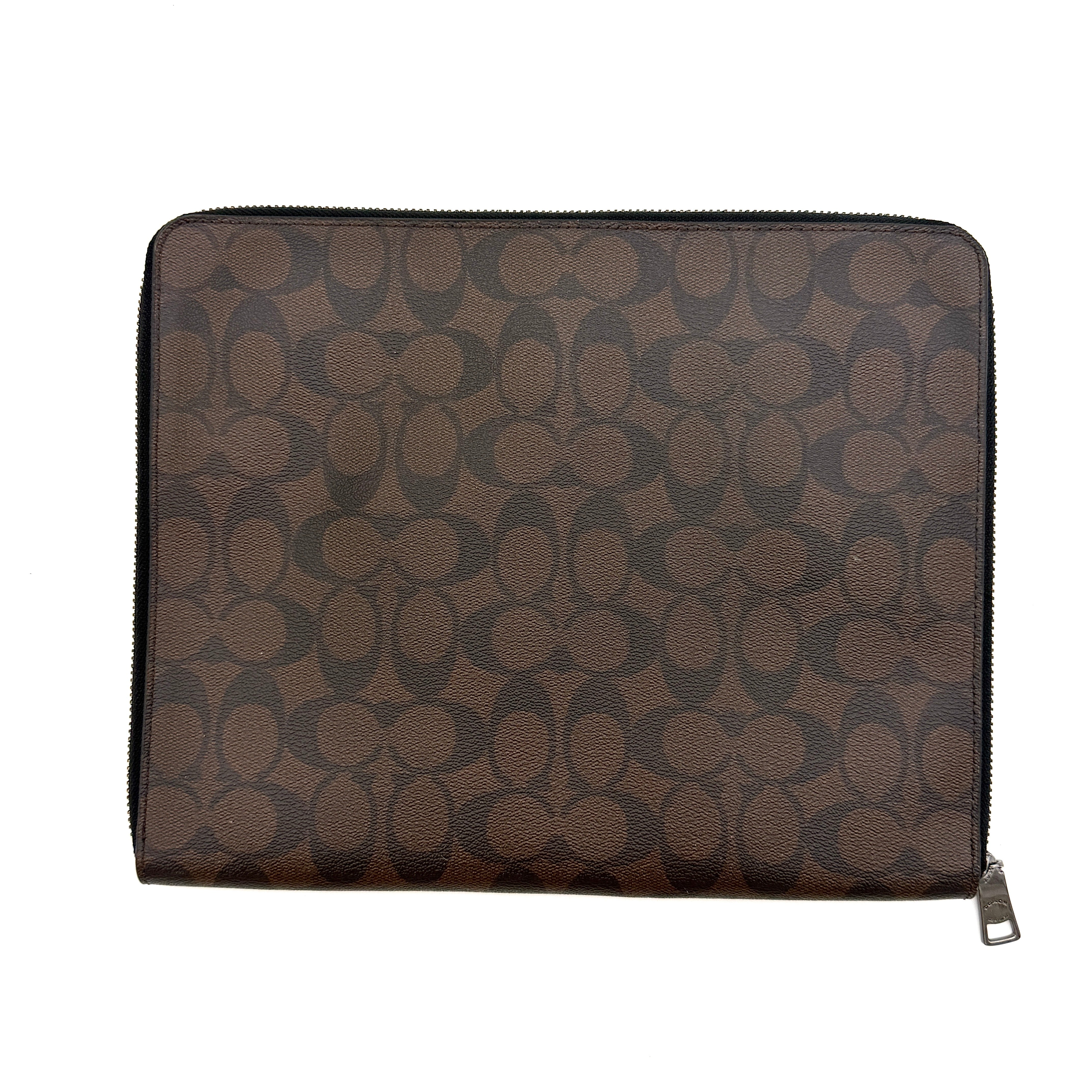 Coach Signature Zip Portfolio in brown and black monogram canvas with zip-around closure, displayed flat against a white background.