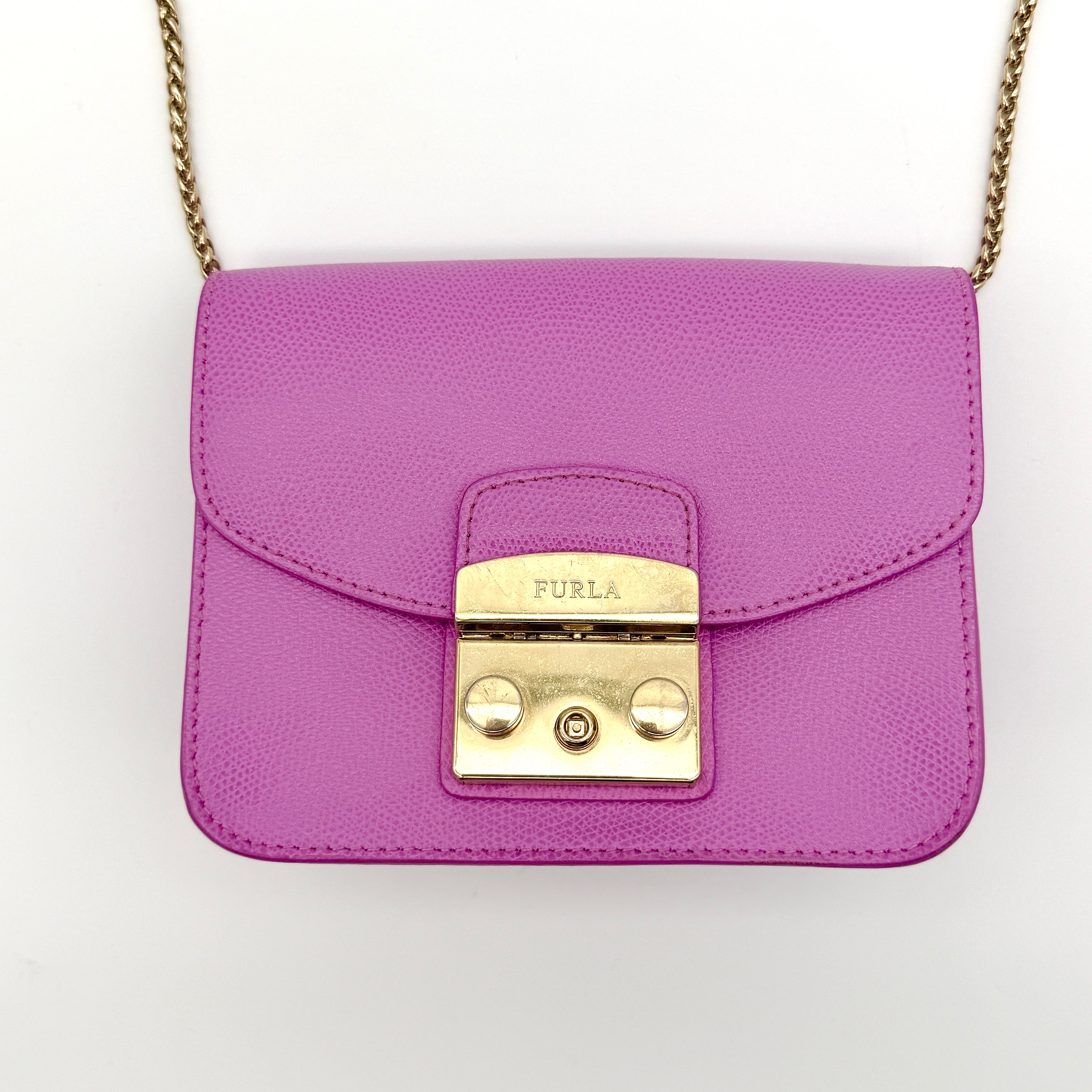 Furla Metropolis crossbody bag in pink grained leather with gold hardware and chain strap, displayed against a white background.