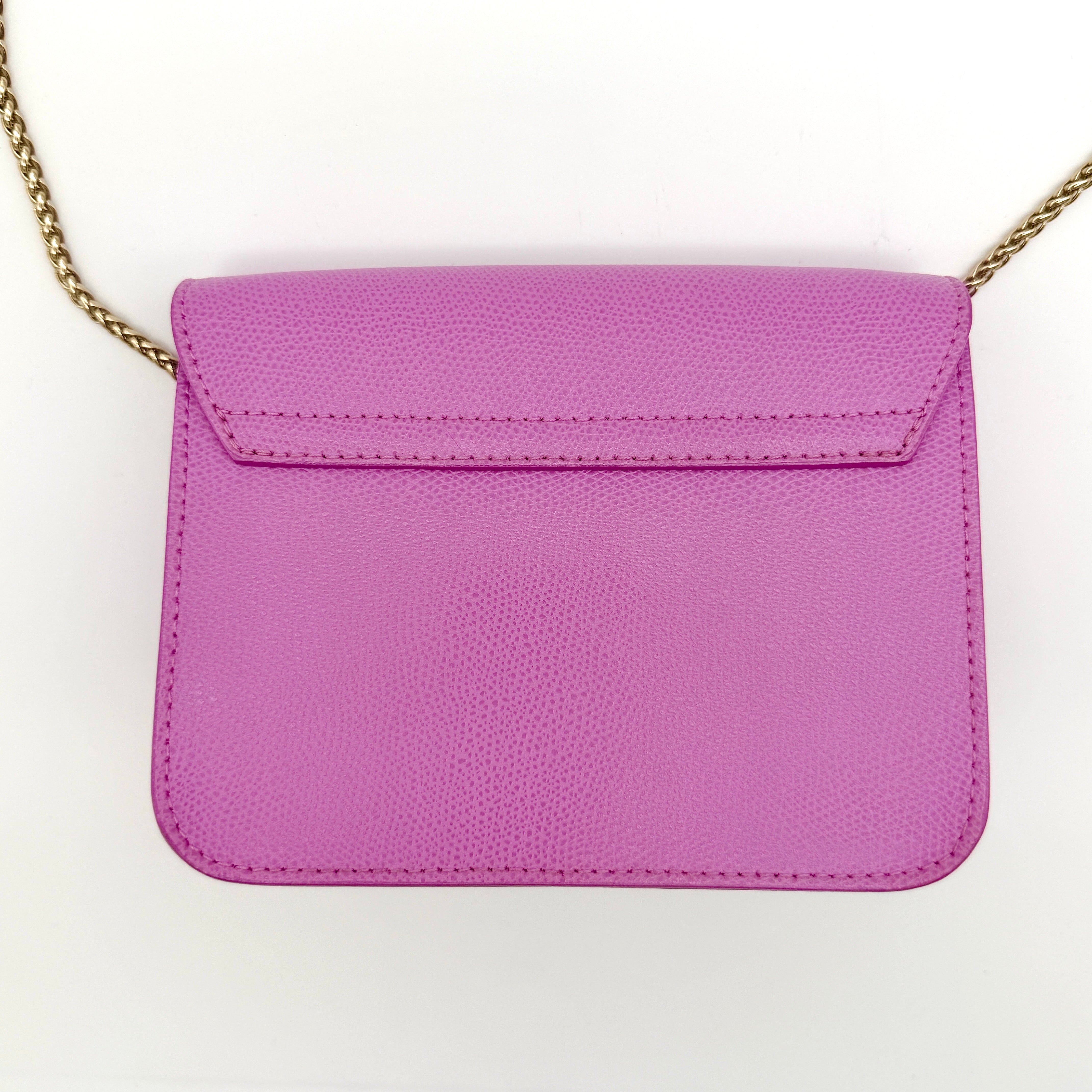 Furla Metropolis crossbody bag in pink grained leather with gold hardware and chain strap, displayed against a white background.
