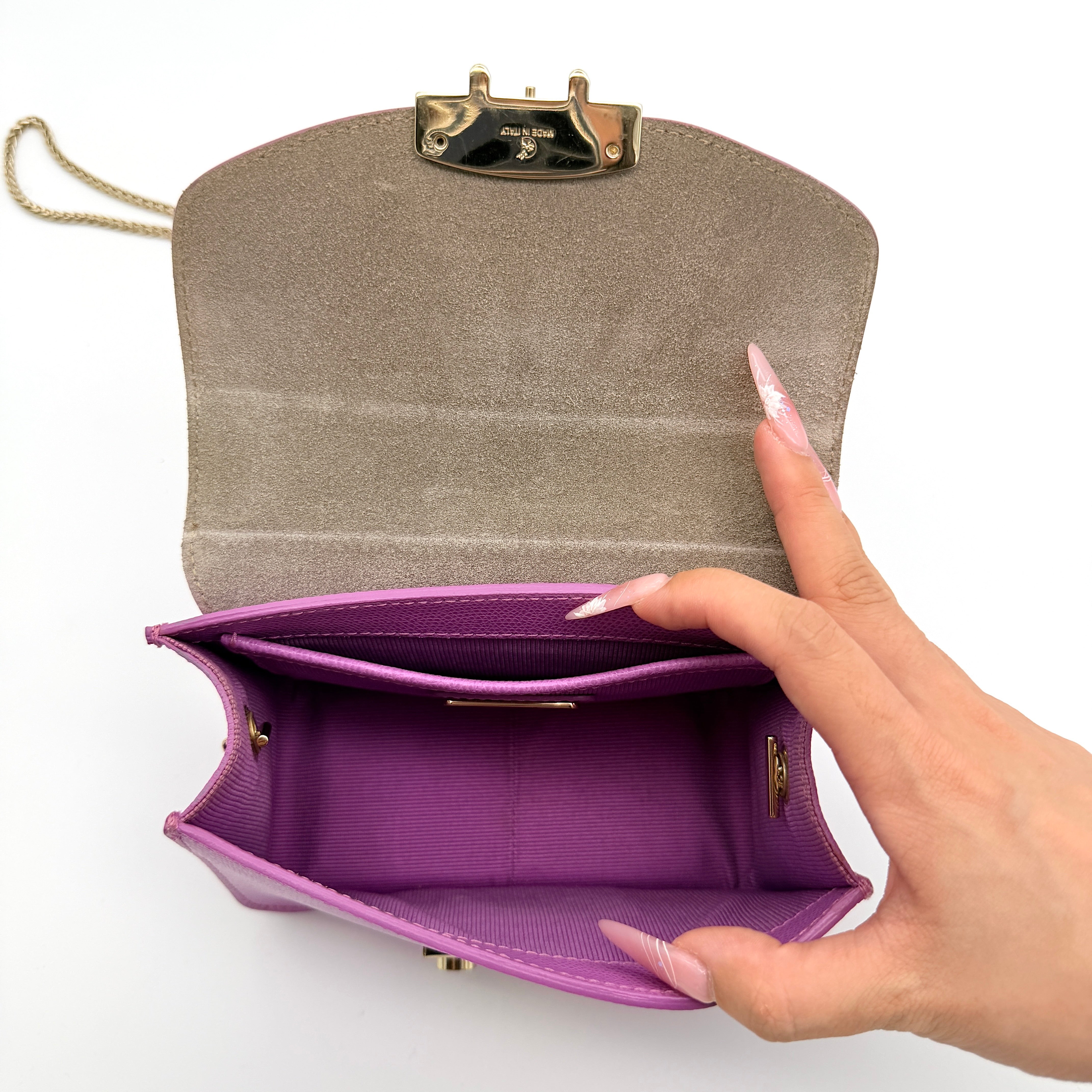 Furla Metropolis crossbody bag in pink grained leather with gold hardware and chain strap, displayed against a white background.