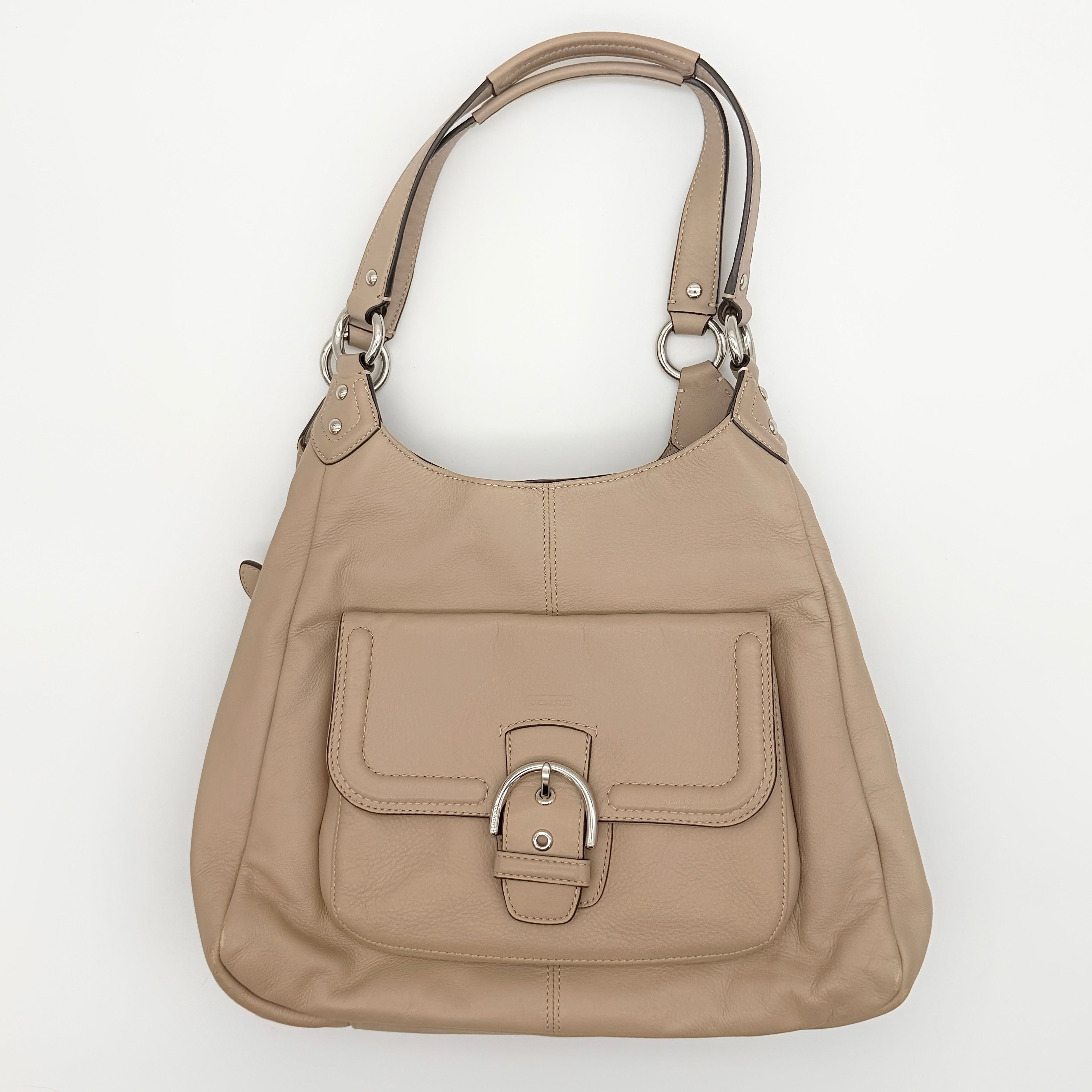 Coach Campbell Hobo shoulder bag in beige leather with silver hardware and front pocket, shown against a white background.