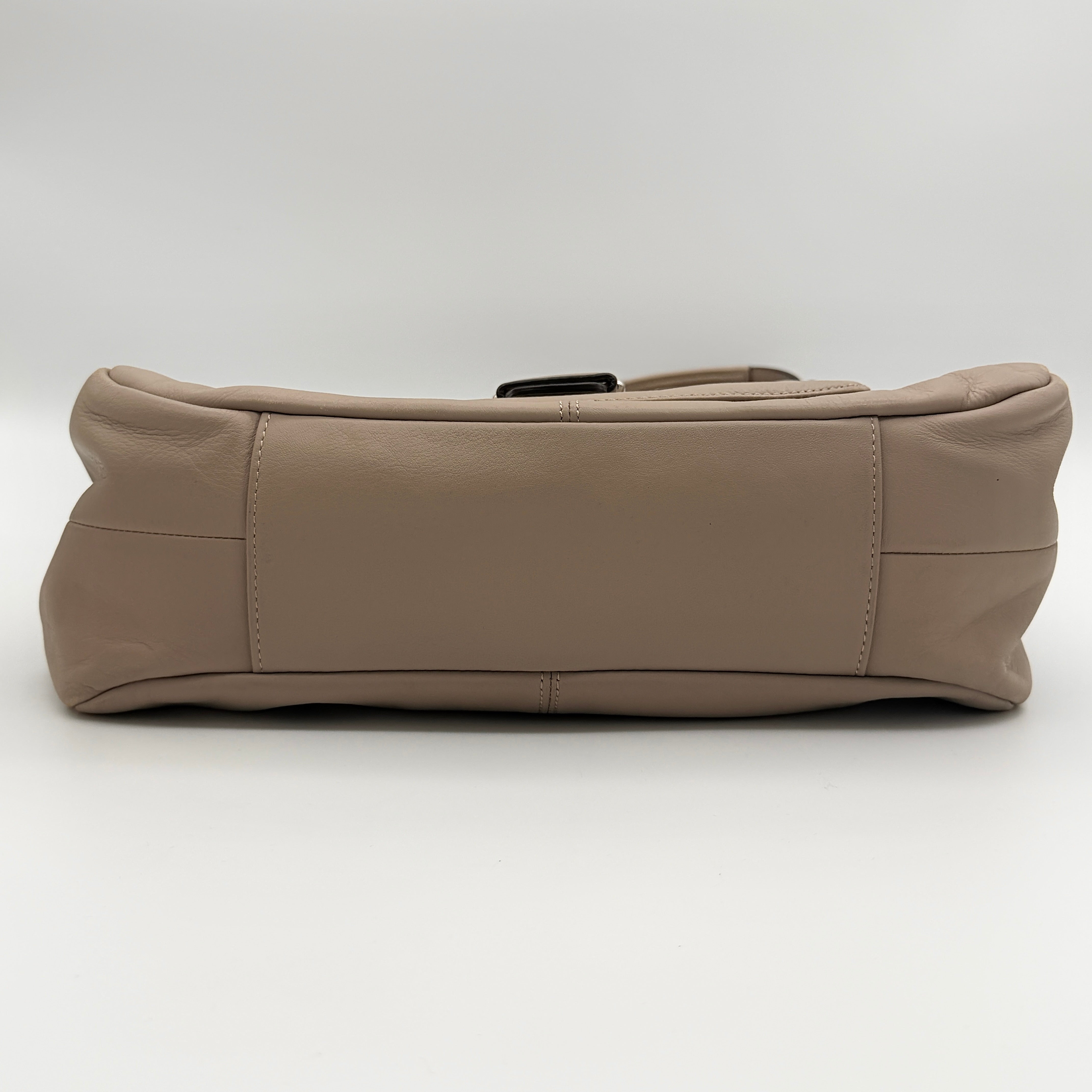 Coach Campbell Hobo shoulder bag in beige leather with silver hardware and front pocket, shown against a white background.