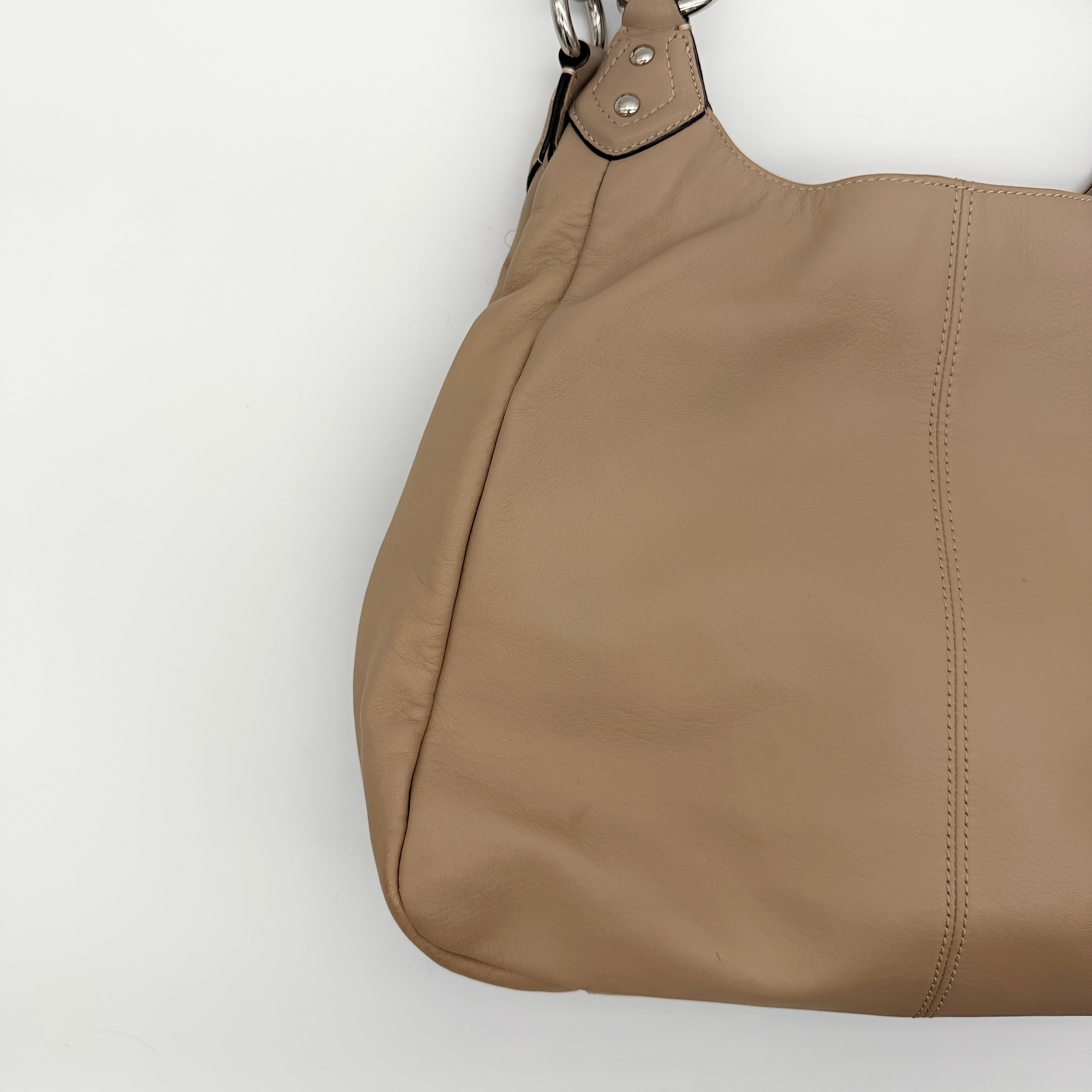 Coach Campbell Hobo shoulder bag in beige leather with silver hardware and front pocket, shown against a white background.