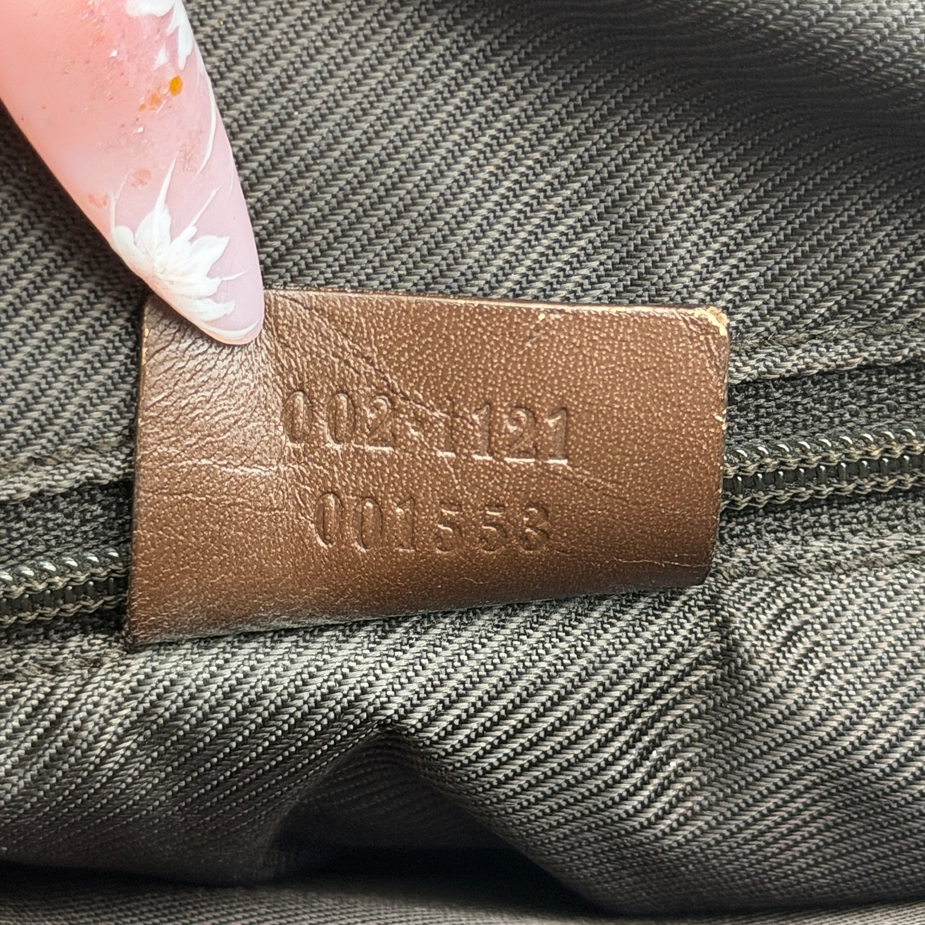 Front view of a Gucci GG Monogram Tote Bag in beige and brown canvas with dark leather trim and structured handles.