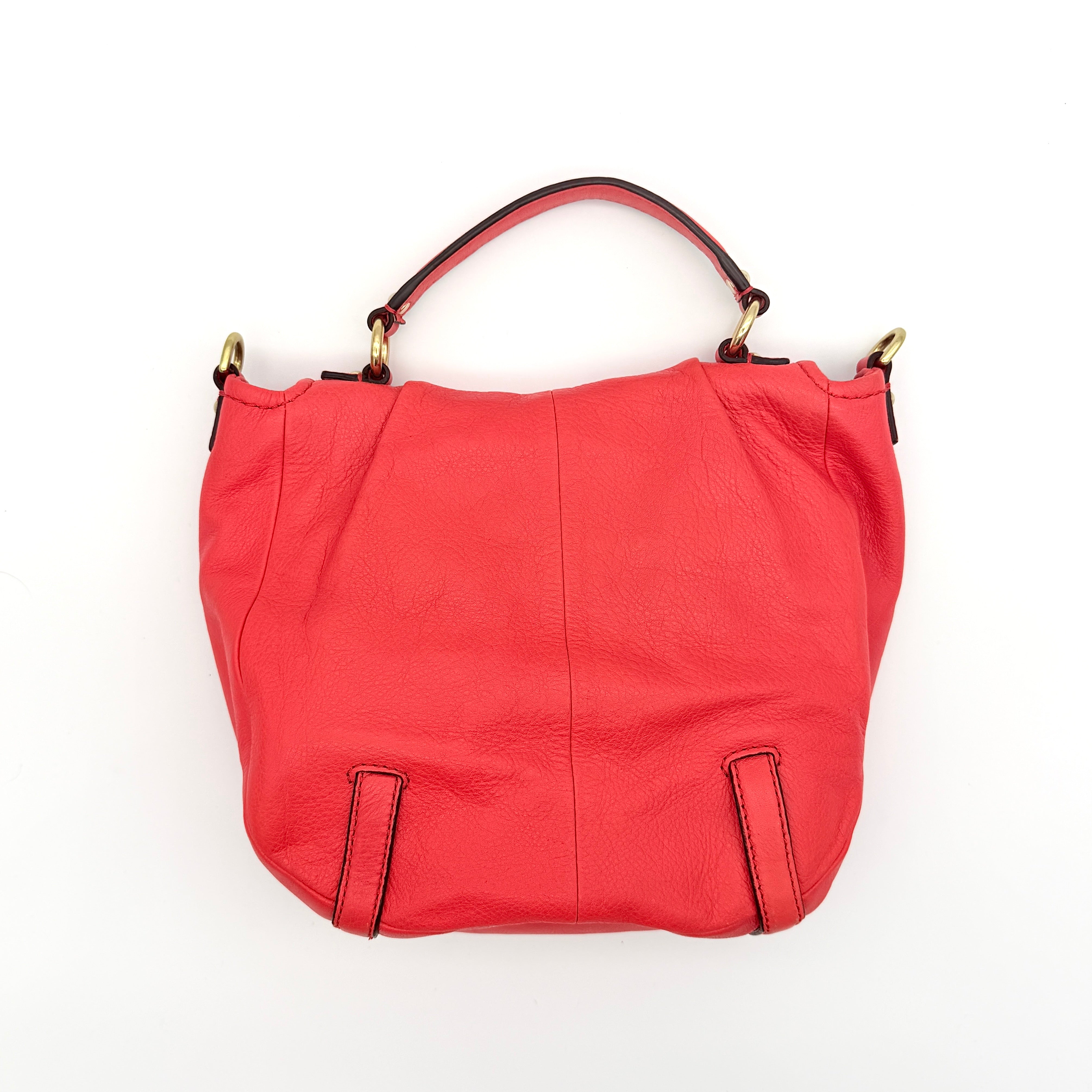 Coach Madison Anabelle red leather handbag with gold tone hardware, top handle, and detachable strap displayed on a white background
