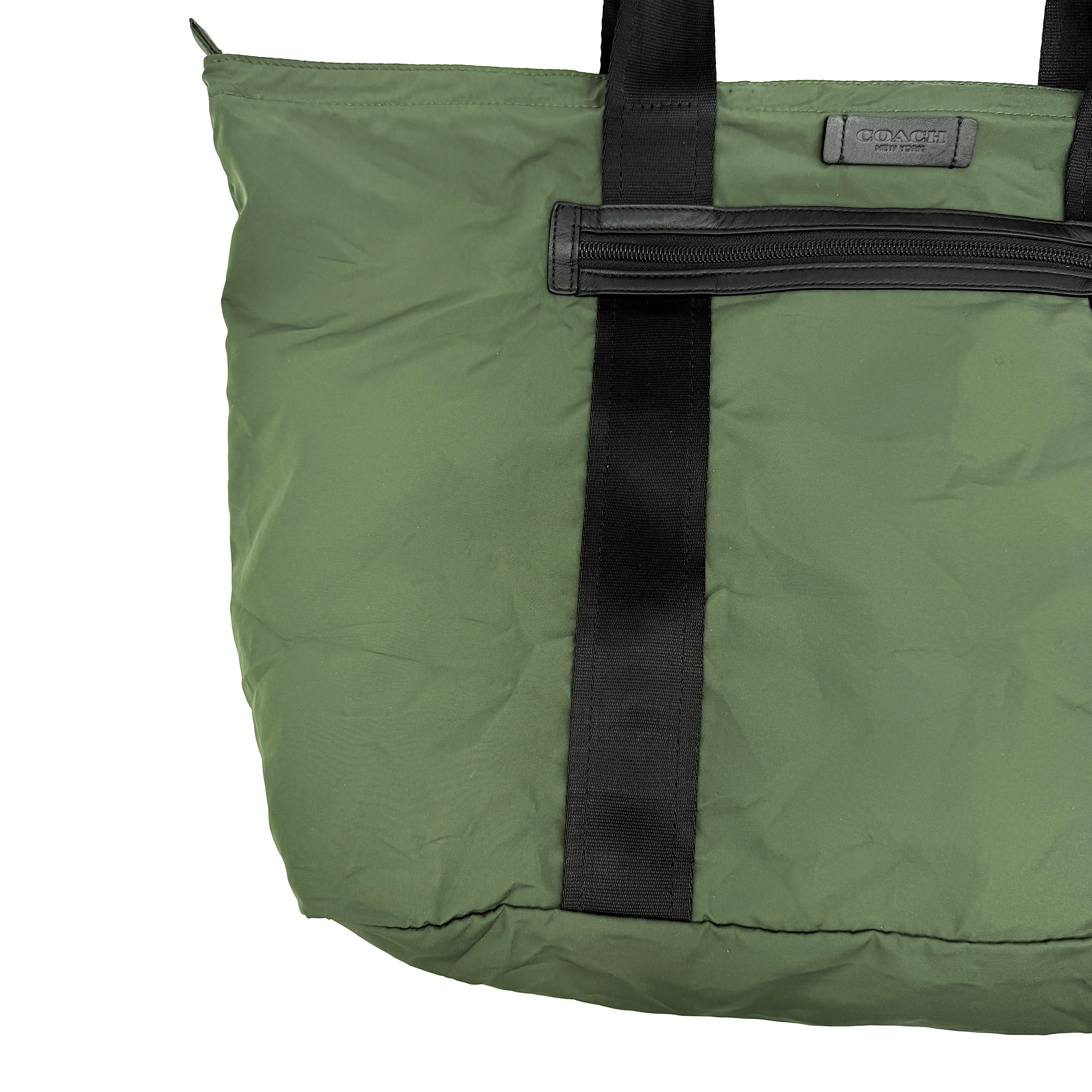 Coach Varick Packable Weekend Tote in green nylon with black web straps and a zippered external pocket.