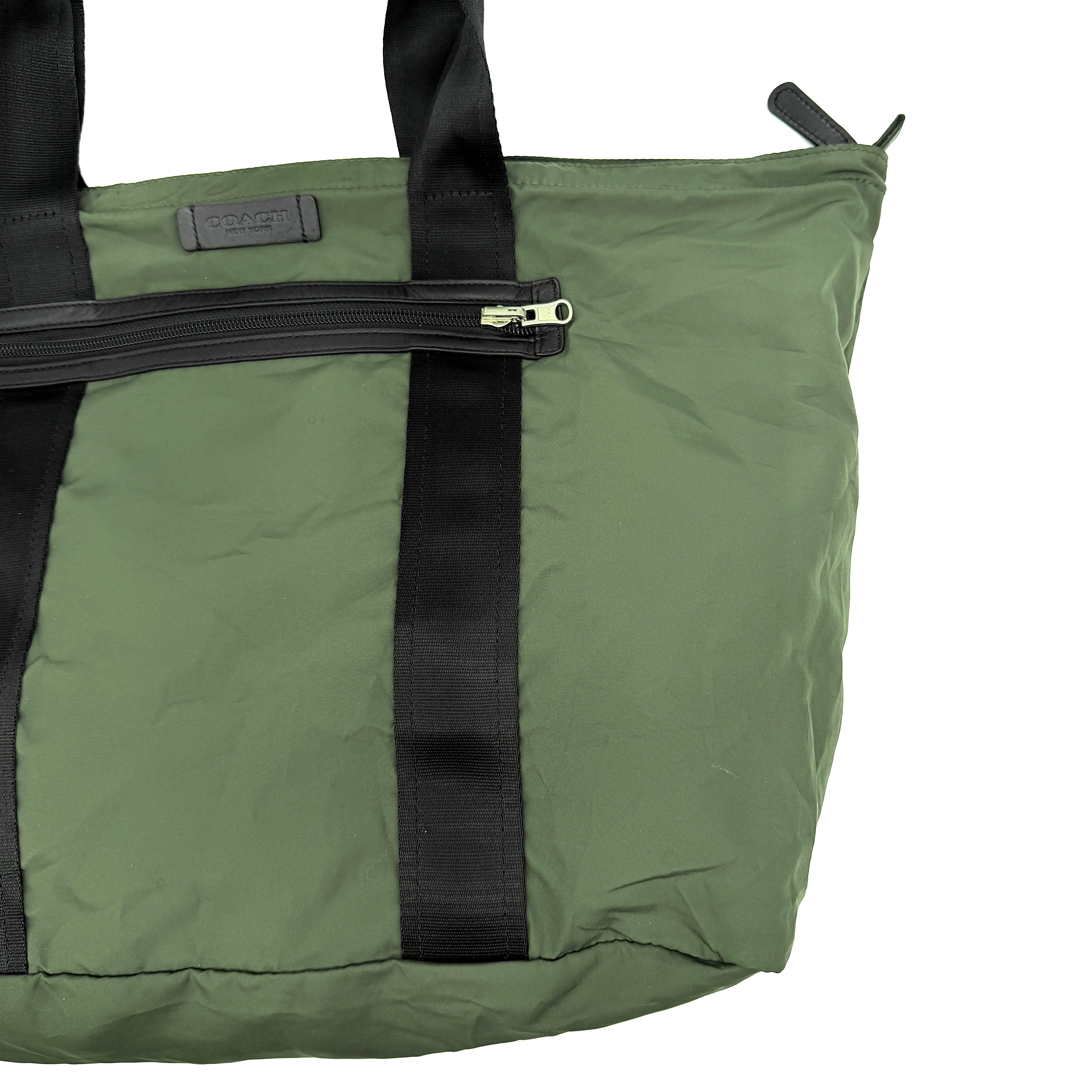 Coach Varick Packable Weekend Tote in green nylon with black web straps and a zippered external pocket.