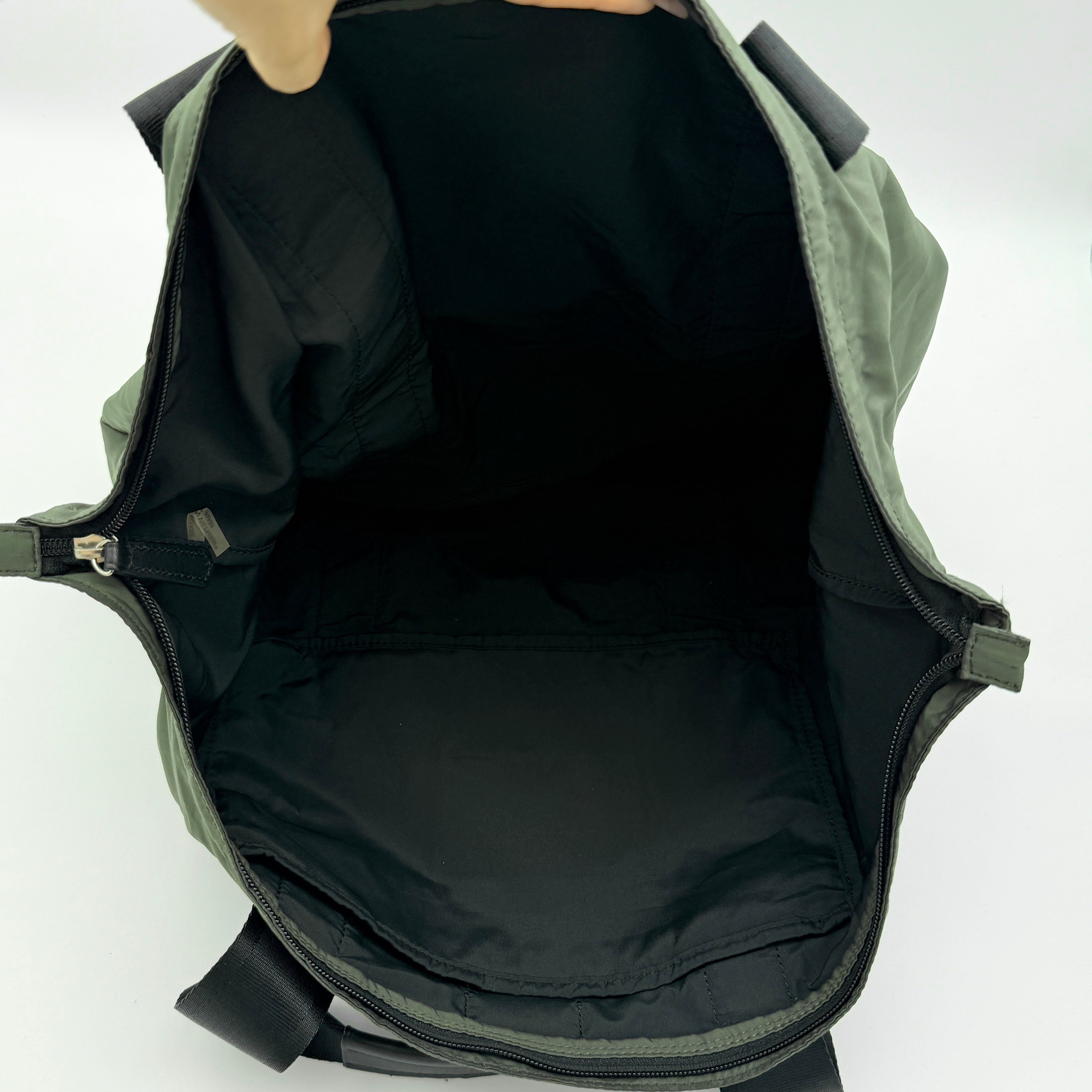 Coach Varick Packable Weekend Tote in green nylon with black web straps and a zippered external pocket.