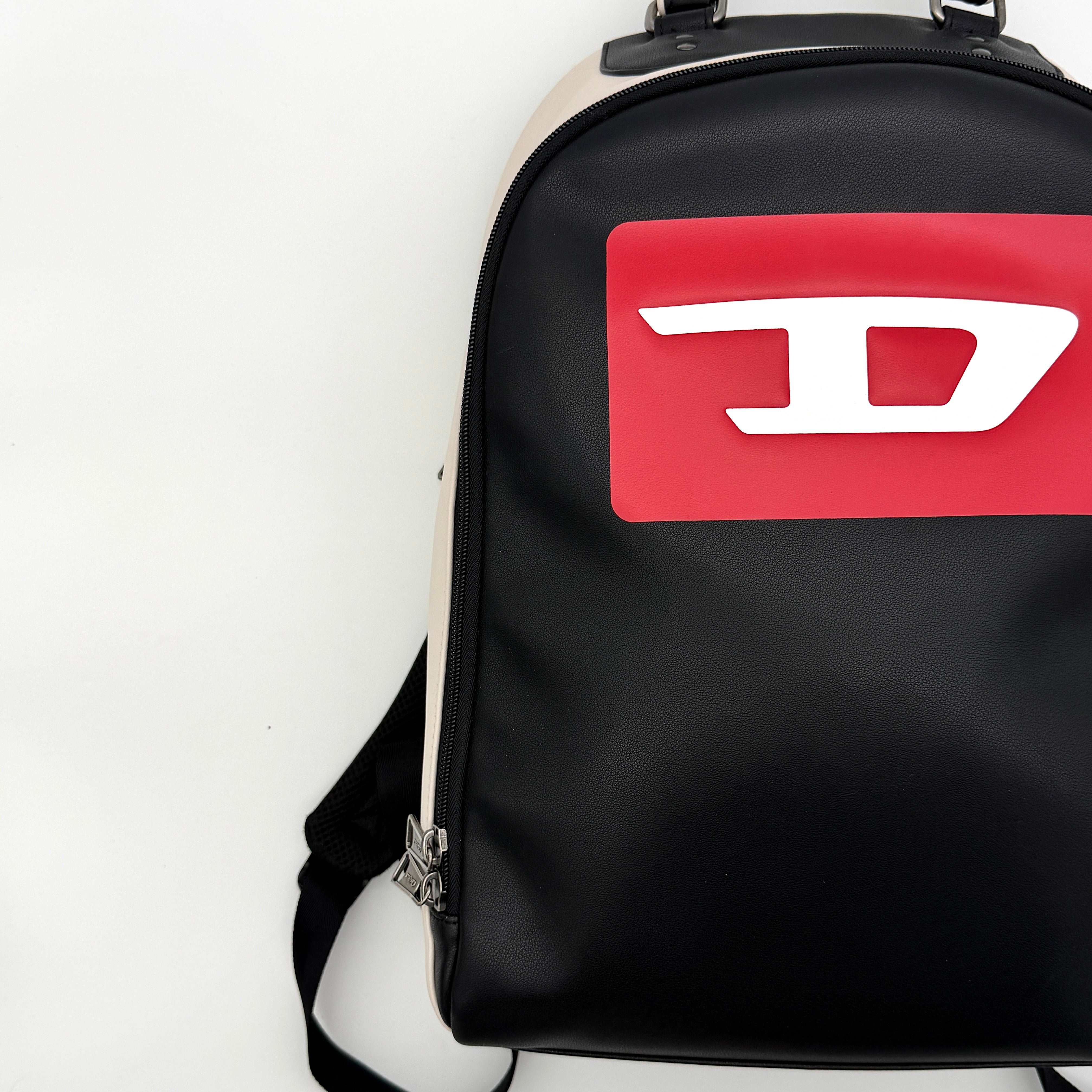 Diesel D-Logo Colorblock Backpack in black and white faux leather with a red logo patch and silver-tone hardware.