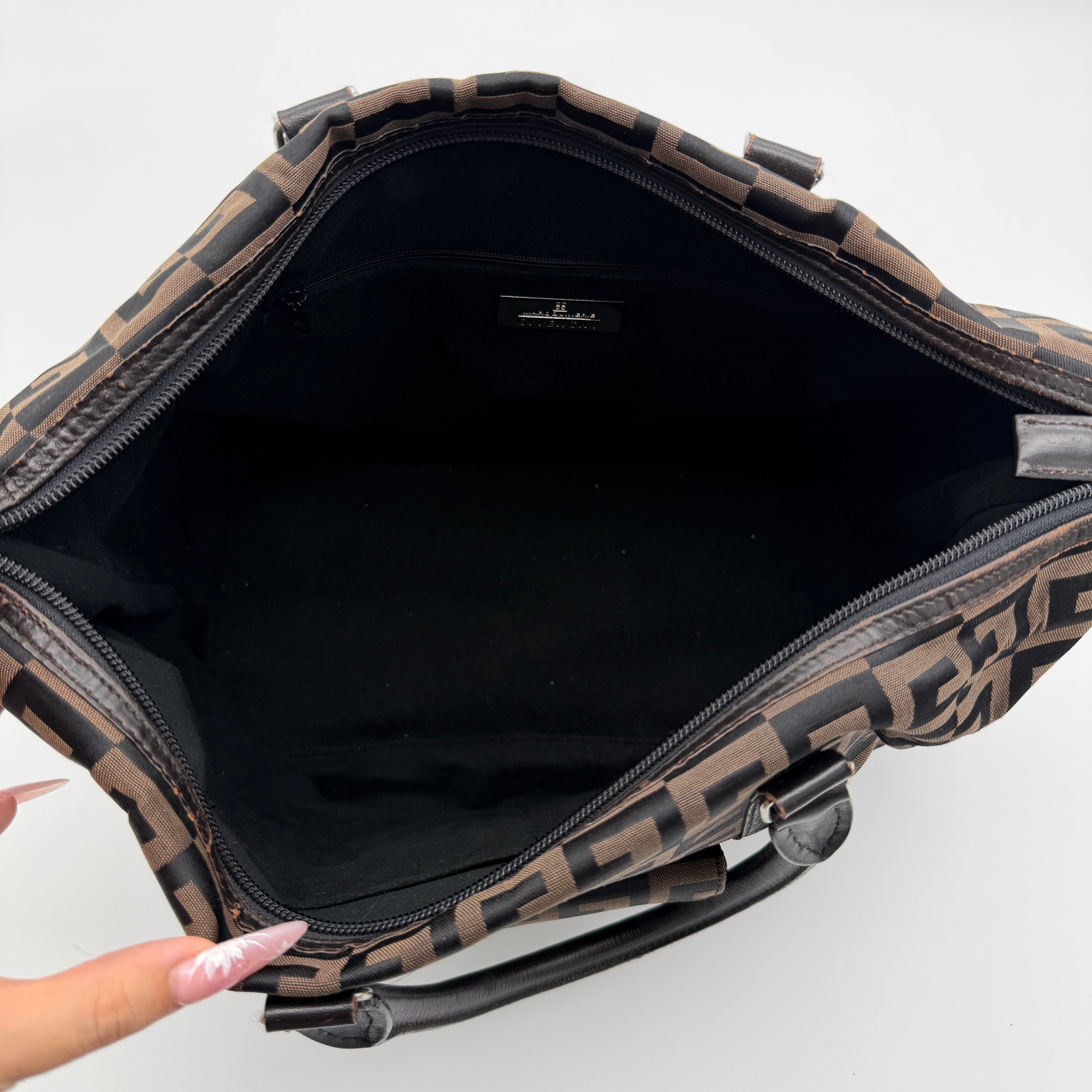Givenchy 4G Monogram Handbag in brown and black fabric with leather handles and bold graphic pattern.