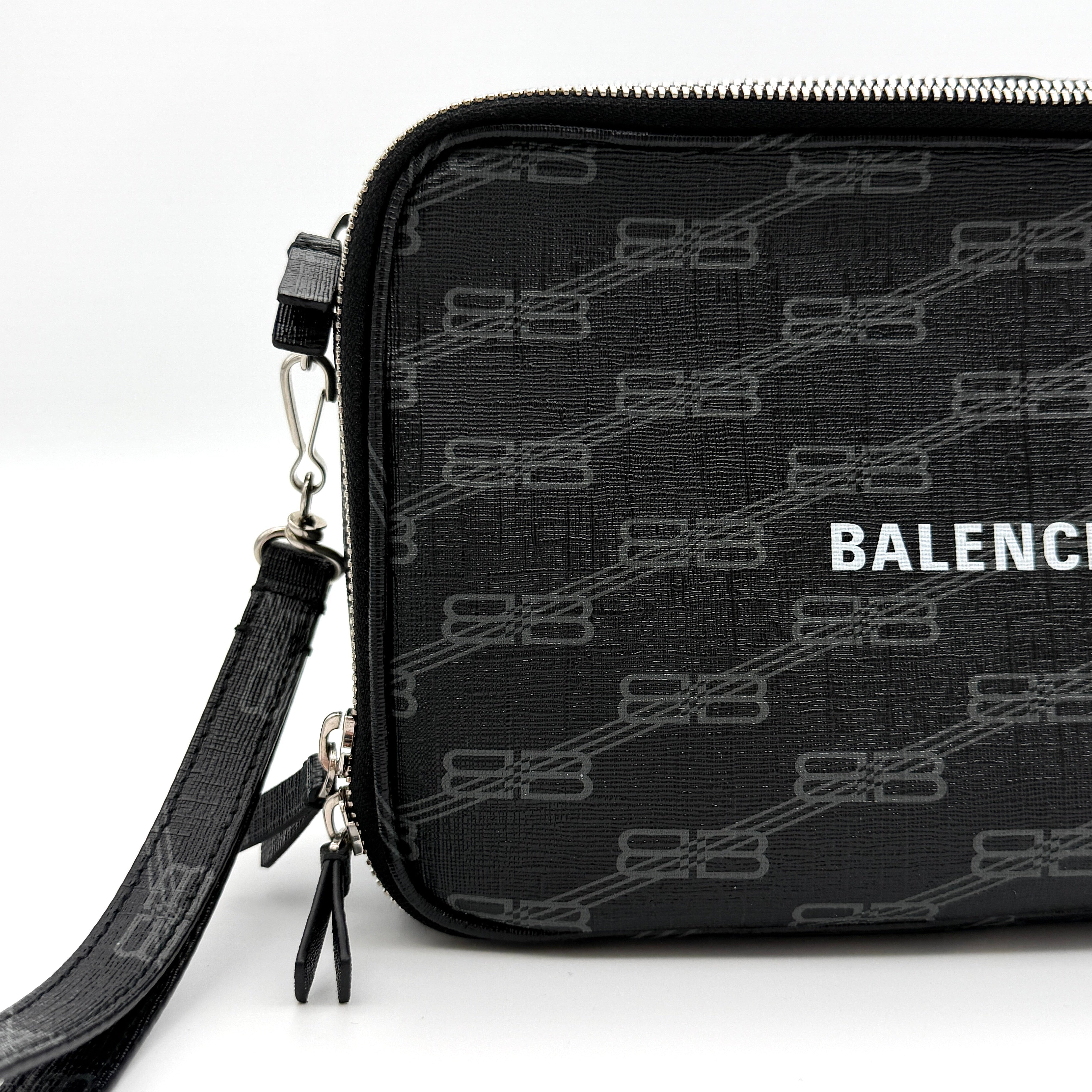Balenciaga Signature BB Monogram Everyday Clutch Bag in black with double zip compartments and detachable wrist strap displayed on a Balenciaga dust bag.