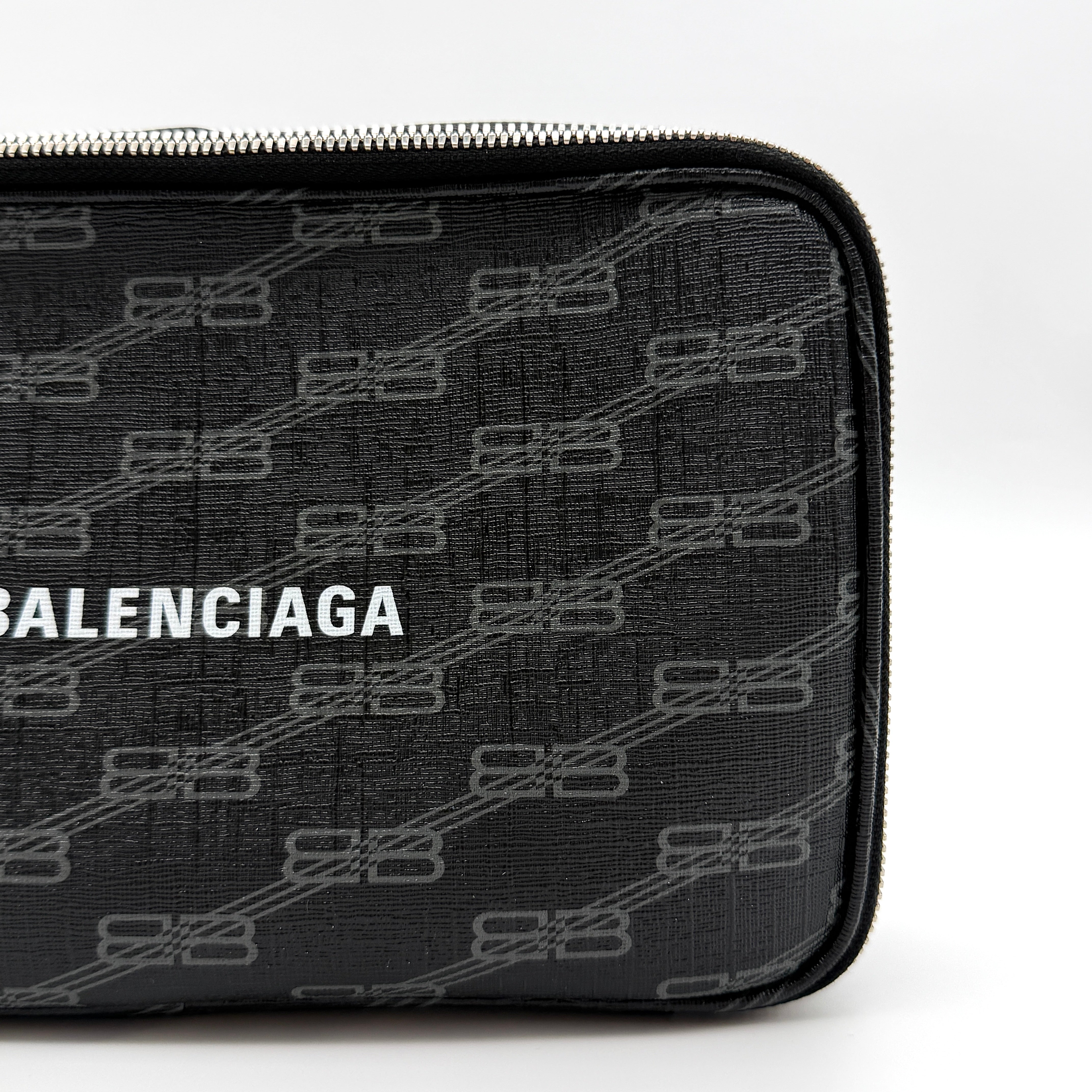 Balenciaga Signature BB Monogram Everyday Clutch Bag in black with double zip compartments and detachable wrist strap displayed on a Balenciaga dust bag.