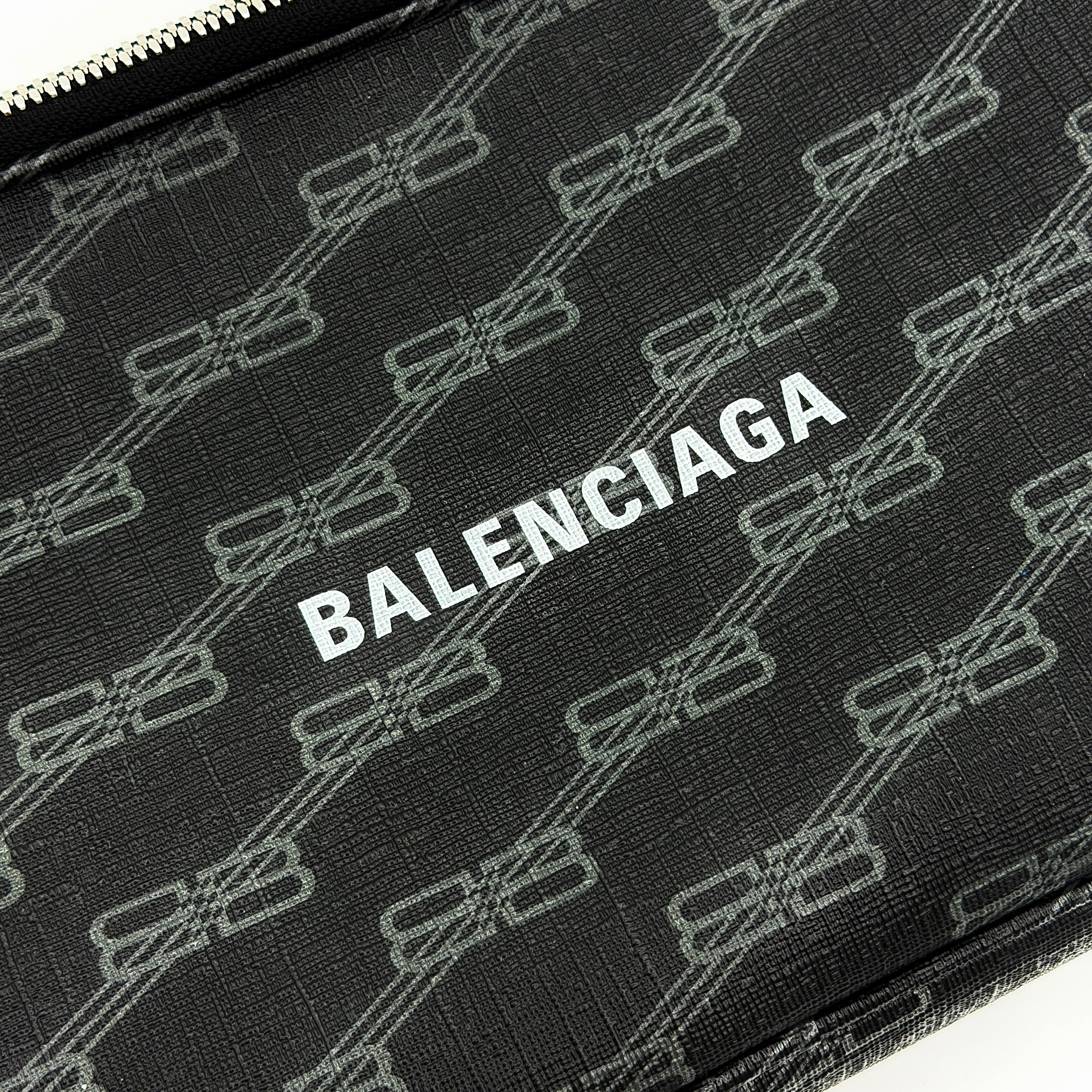 Balenciaga Signature BB Monogram Everyday Clutch Bag in black with double zip compartments and detachable wrist strap displayed on a Balenciaga dust bag.