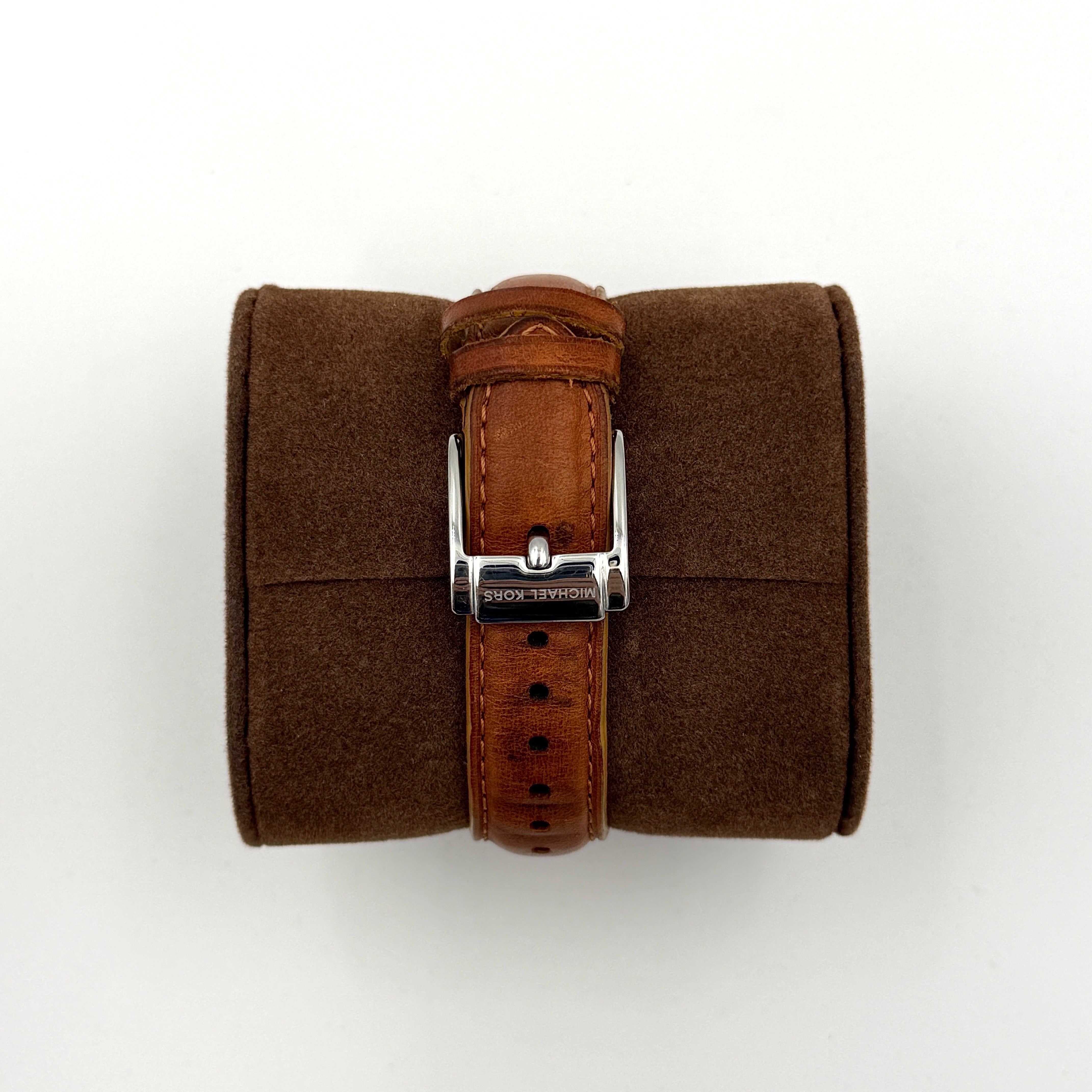 Michael Kors MK-2301 gold and silver tone chronograph watch with brown leather strap, showcased on a brown cushion atop the branded box.
