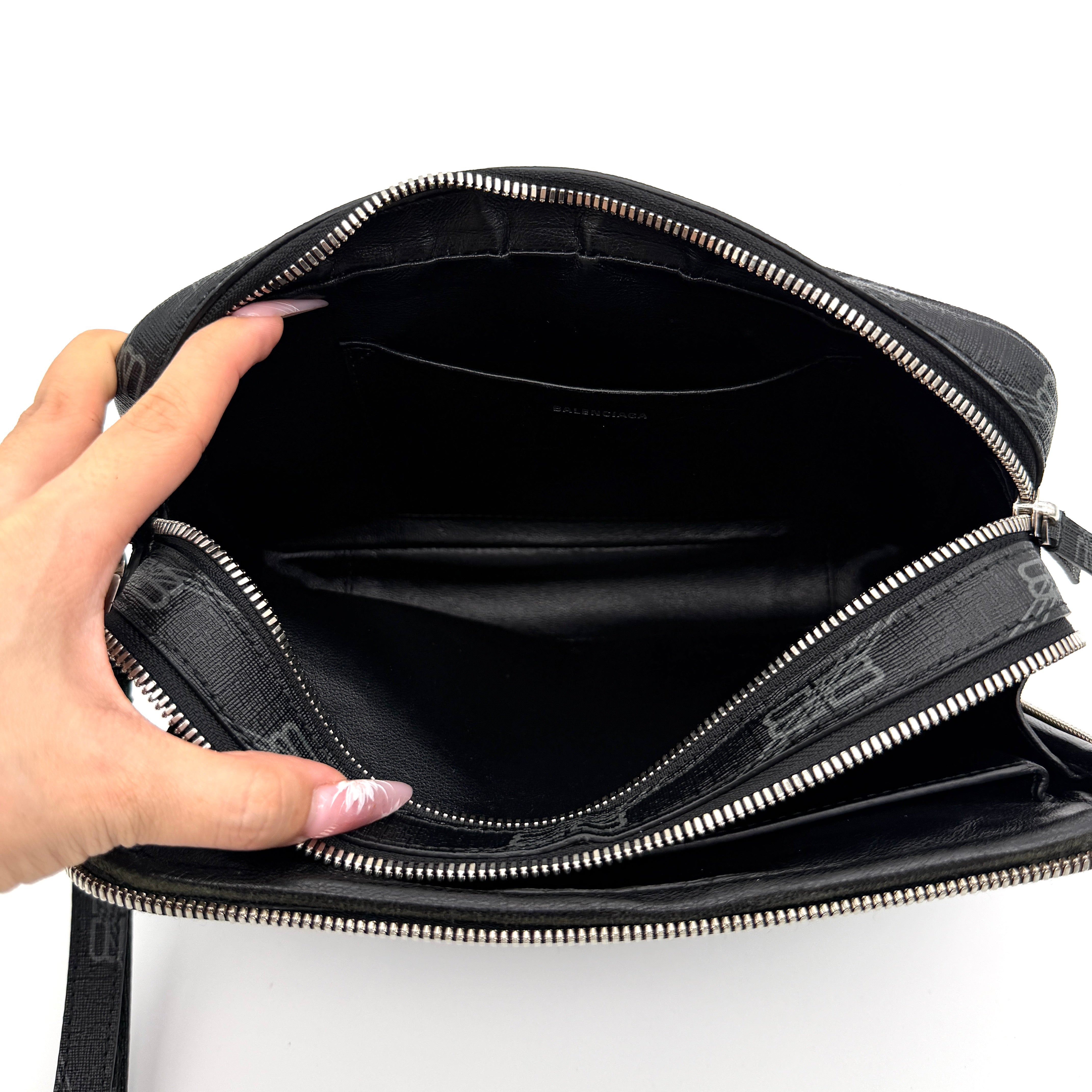 Balenciaga Signature BB Monogram Everyday Clutch Bag in black with double zip compartments and detachable wrist strap displayed on a Balenciaga dust bag.