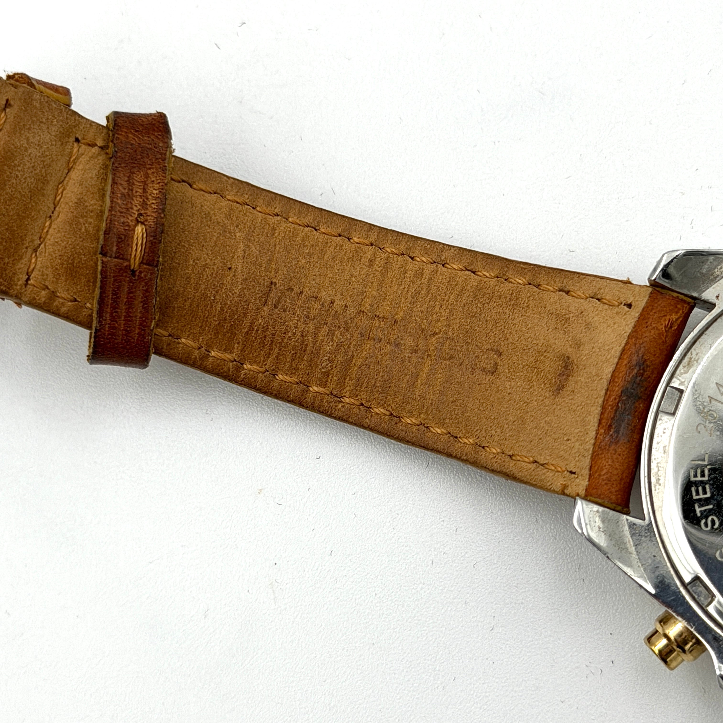 Michael Kors MK-2301 gold and silver tone chronograph watch with brown leather strap, showcased on a brown cushion atop the branded box.
