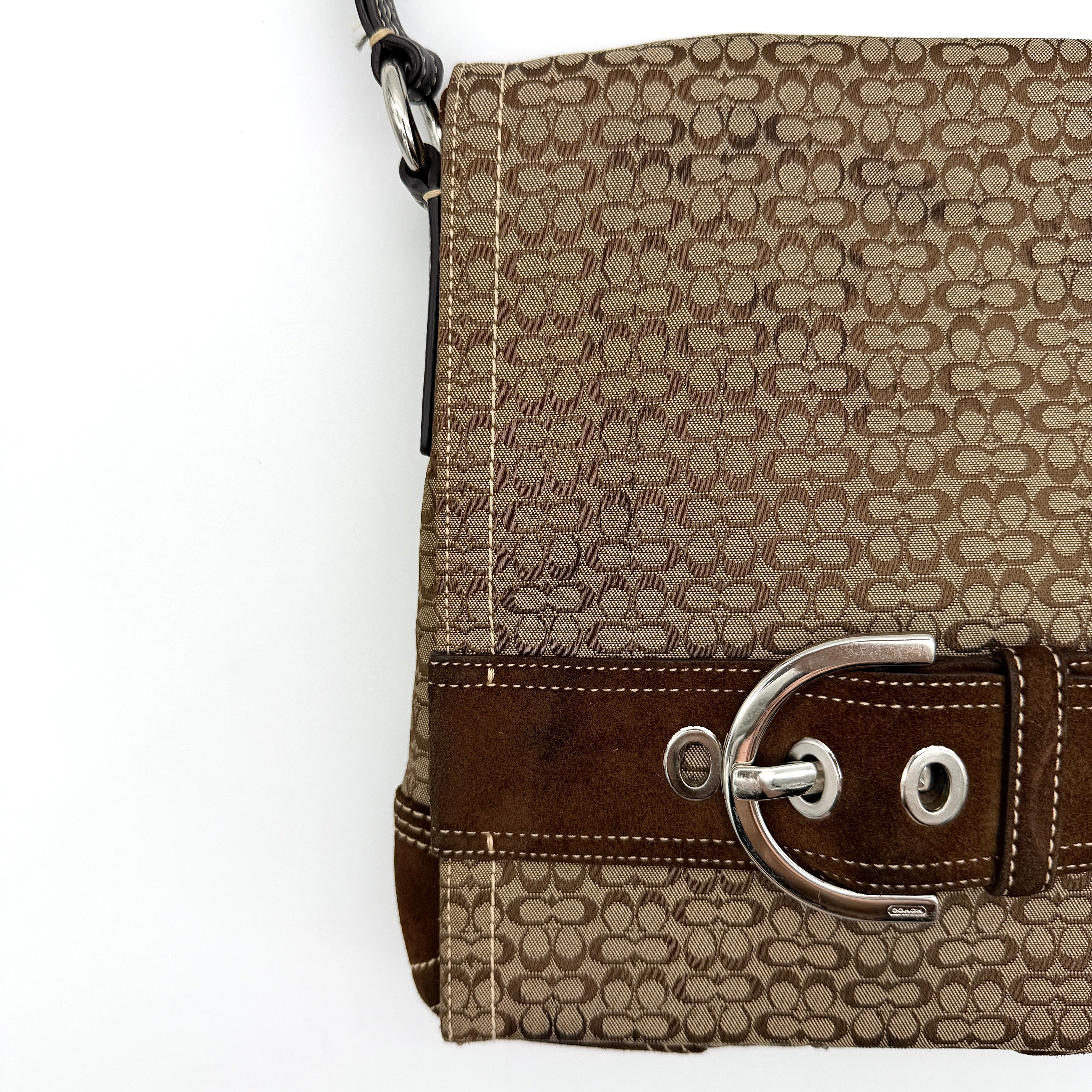 Coach Signature Soho Flap Crossbody Bag in brown jacquard canvas with suede trim and silver buckle, shown with adjustable strap.