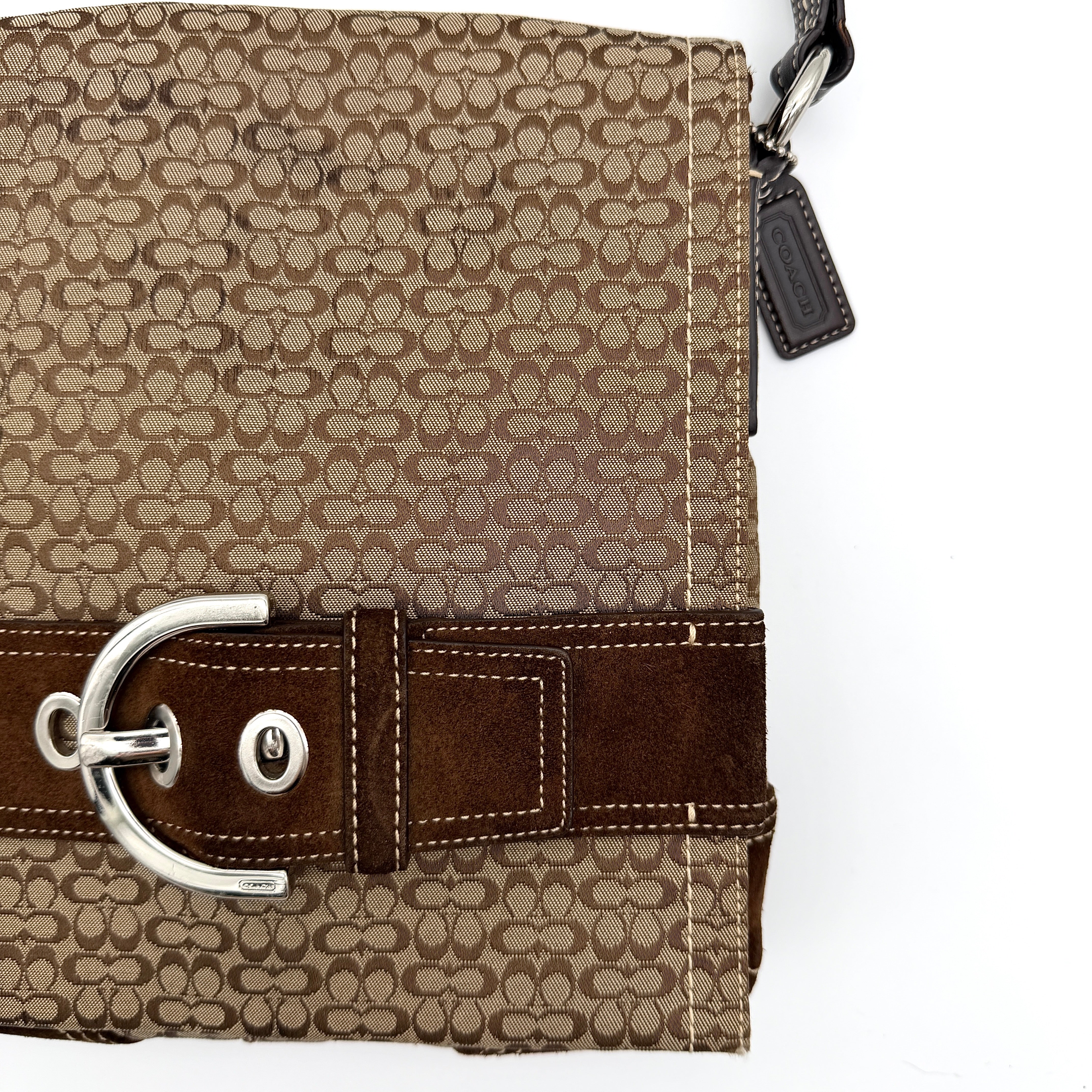 Coach Signature Soho Flap Crossbody Bag in brown jacquard canvas with suede trim and silver buckle, shown with adjustable strap.