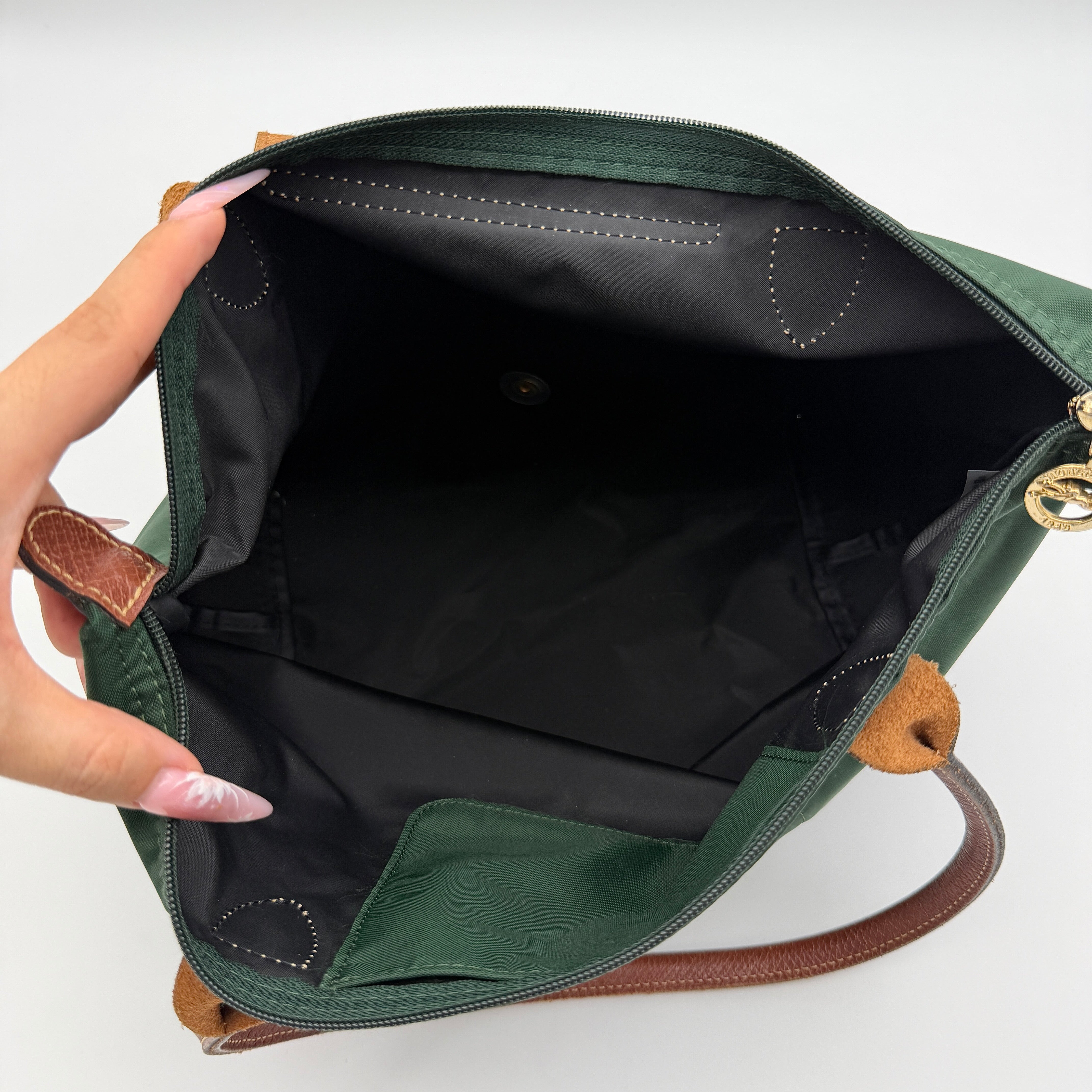 Longchamp Le Pliage Original Tote in green nylon with brown leather handles and gold hardware displayed against a white background.