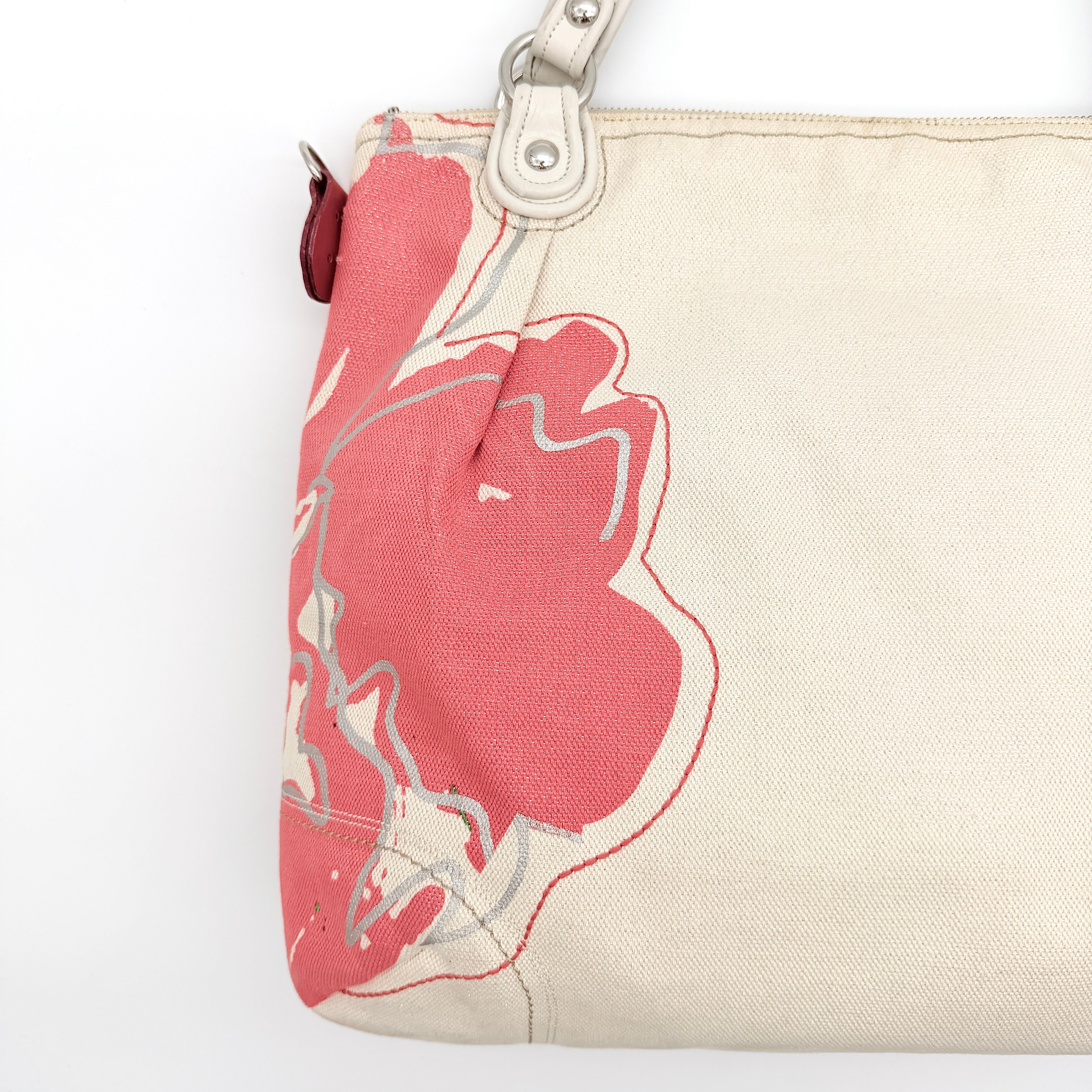 Coach Poppy Glam Floral Shoulder Bag in canvas with a bold multicolour floral print and cream leather handles, photographed on white.
