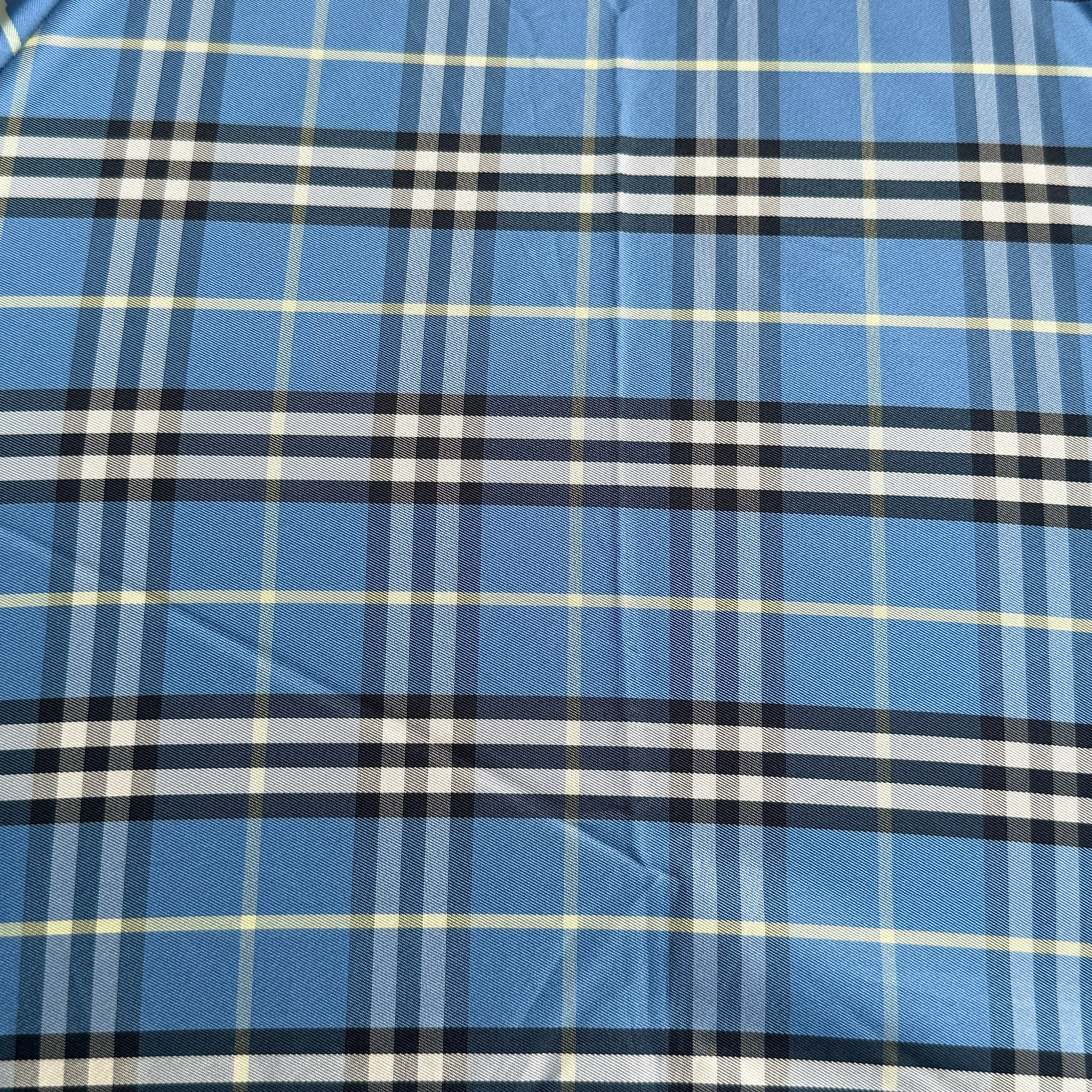 Burberry folding umbrella and matching pouch in blue Nova Check plaid, perfectly folded to showcase its classic pattern and refined finish.