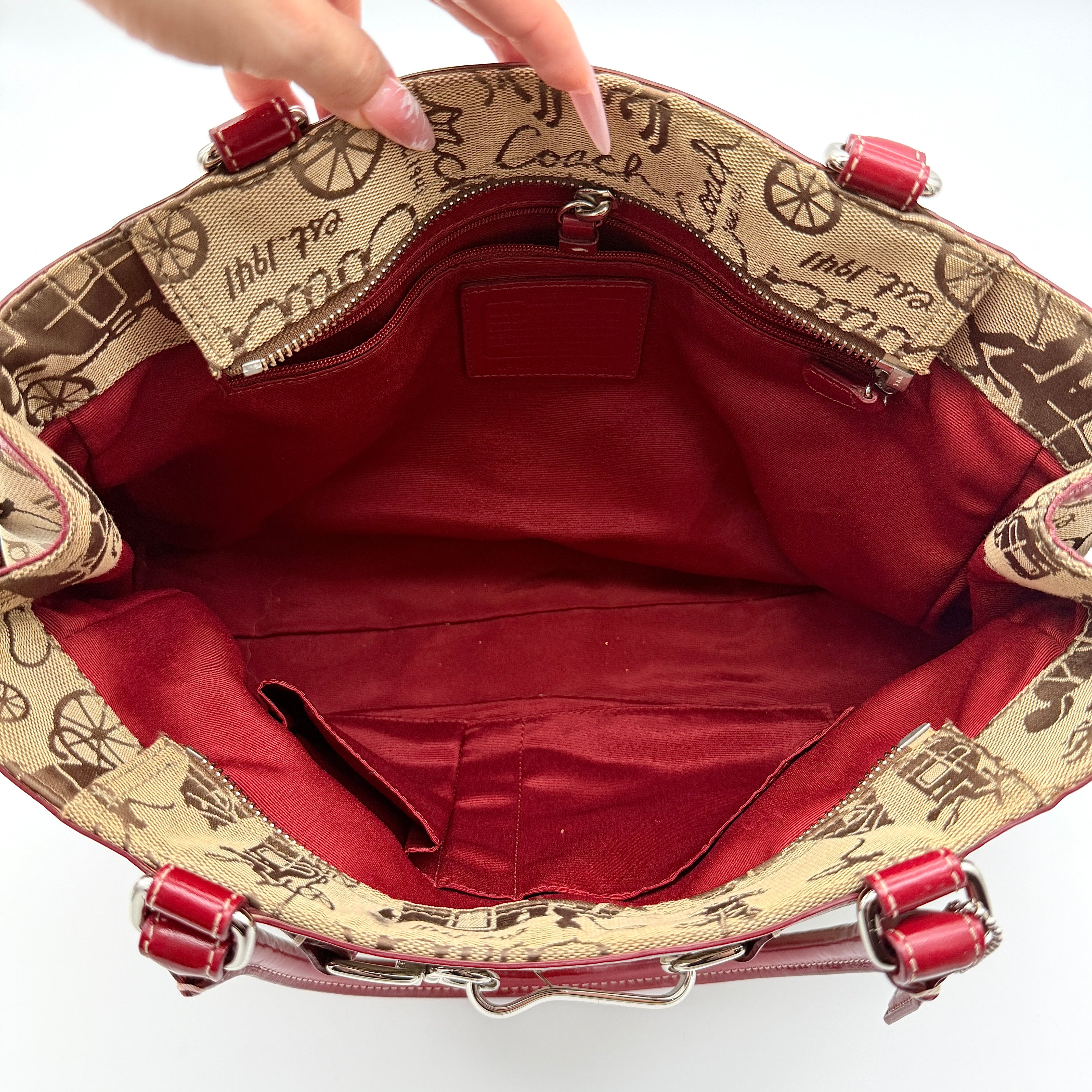 Coach Hampton Carryall in beige canvas with horse carriage motif, red leather trim, and double handles.
