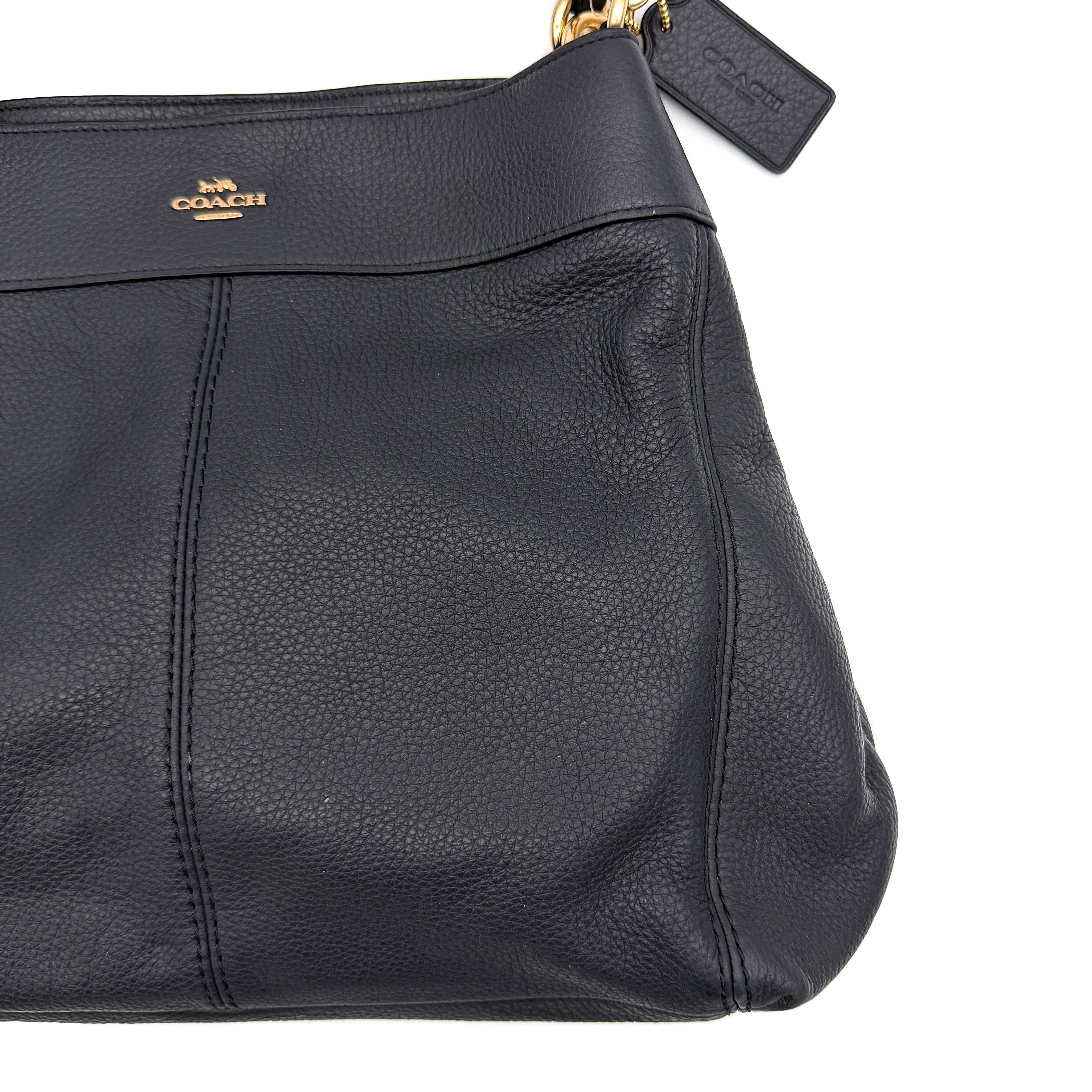 Coach Lexy shoulder bag in navy pebbled leather with gold-tone hardware and double handles.