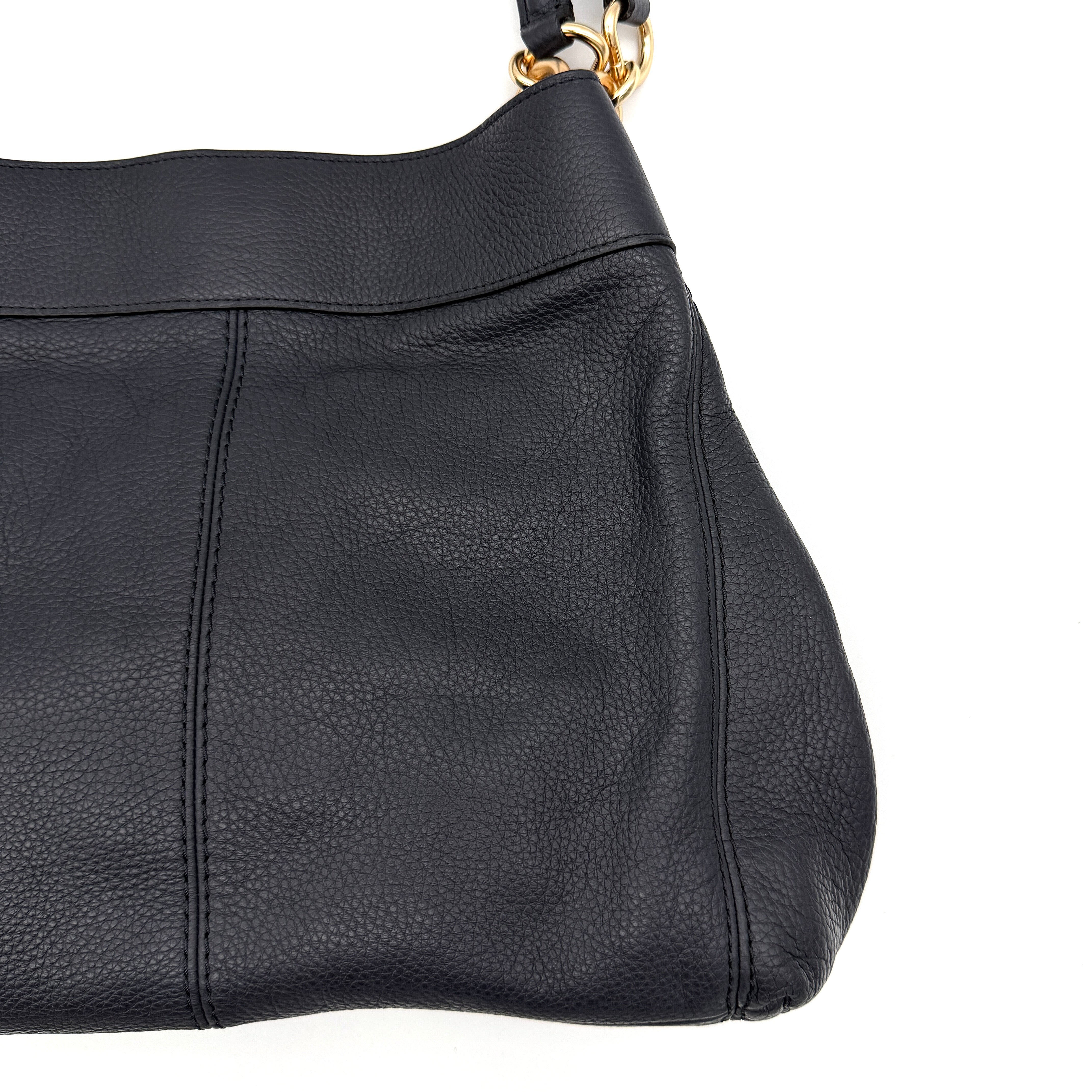 Coach Lexy shoulder bag in navy pebbled leather with gold-tone hardware and double handles.
