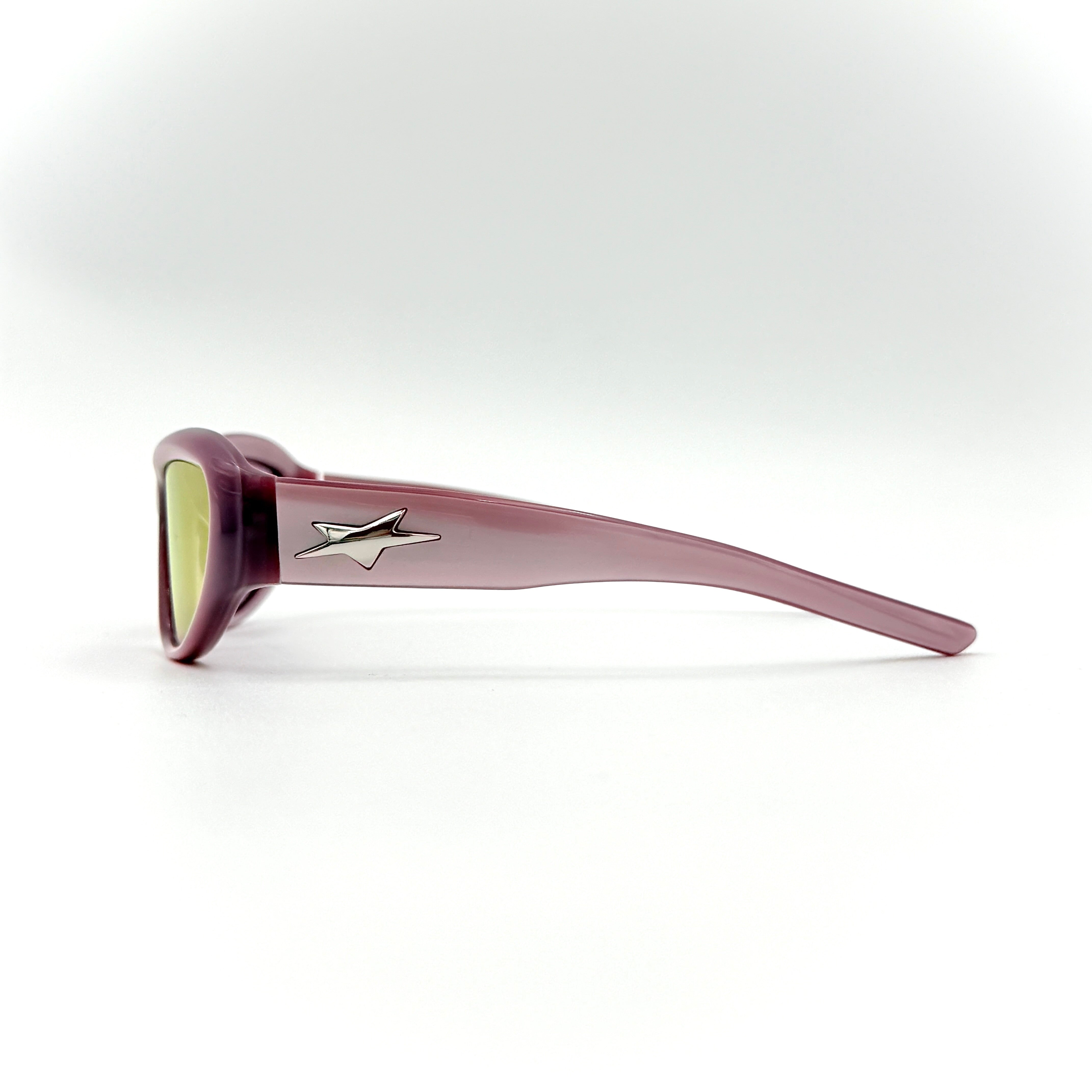 Gentle Monster R.E.A.T sunglasses in translucent pink acetate with mirrored pink lenses and silver star hardware, displayed alongside a chrome hard case.