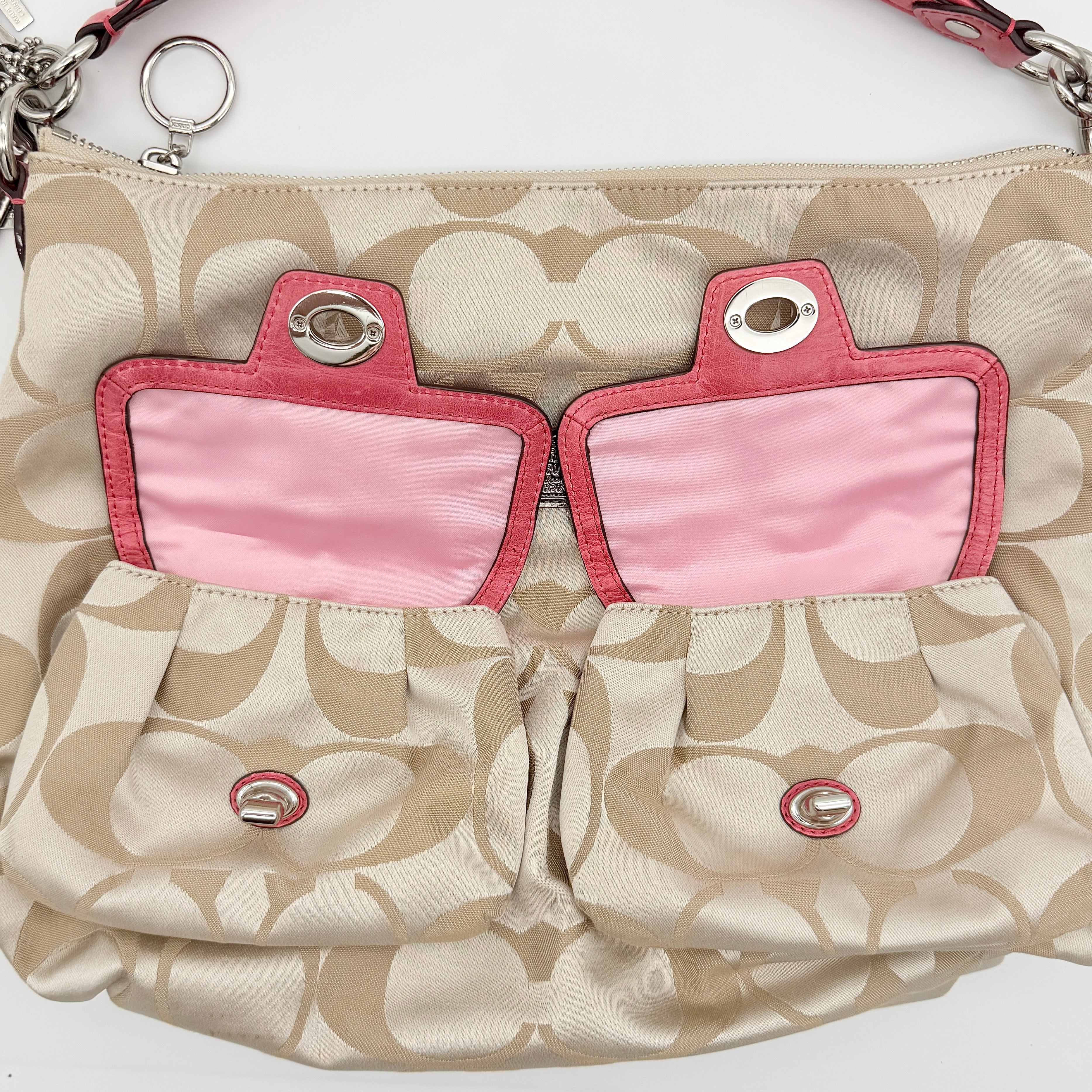 Coach Signature Poppy Pocket Hobo in beige sateen canvas with pink leather trim and silver hardware, front view with double pockets and charms.