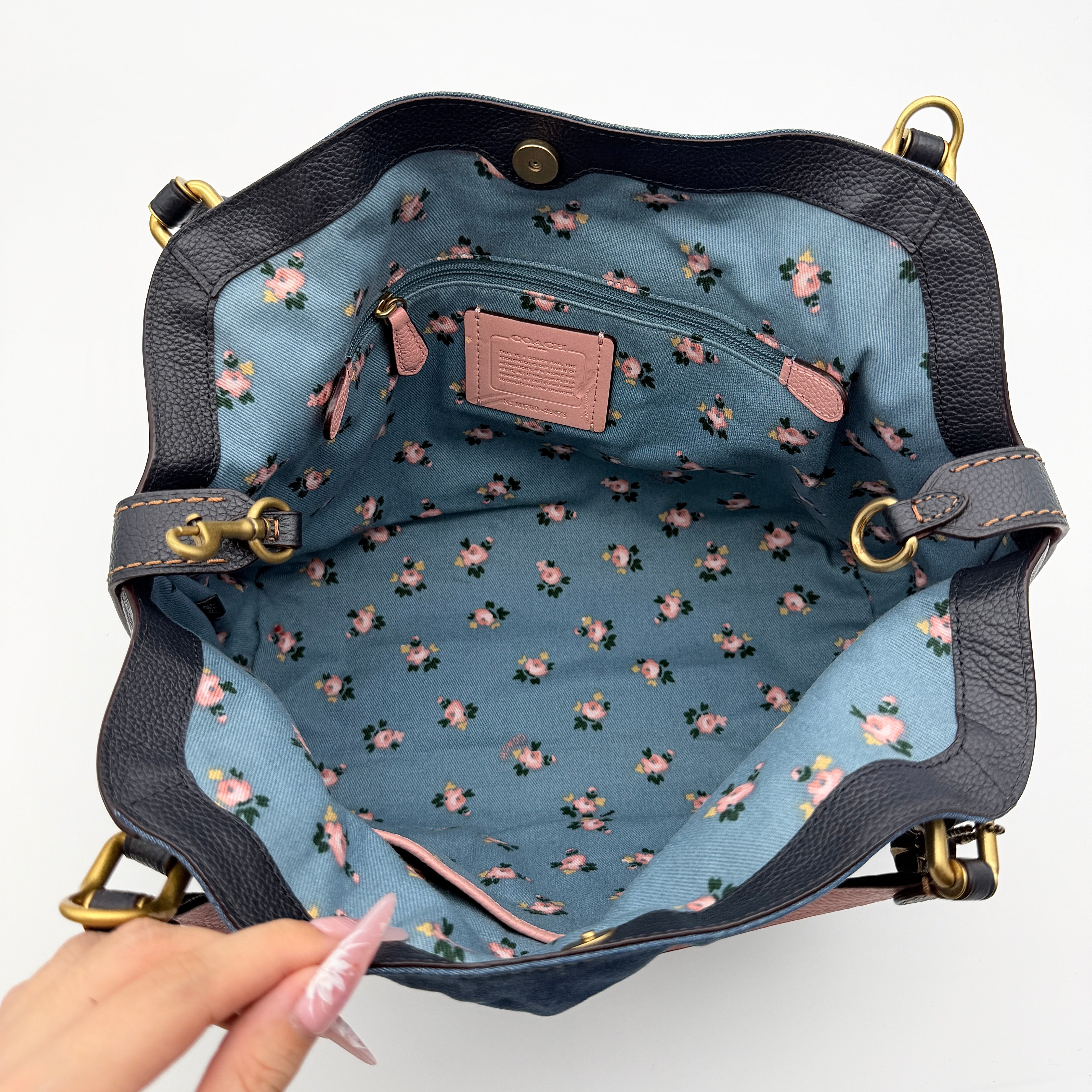 Coach Edie 2Way shoulder bag in navy denim with black leather trim, pink accents and gold hardware, shown with detachable strap.