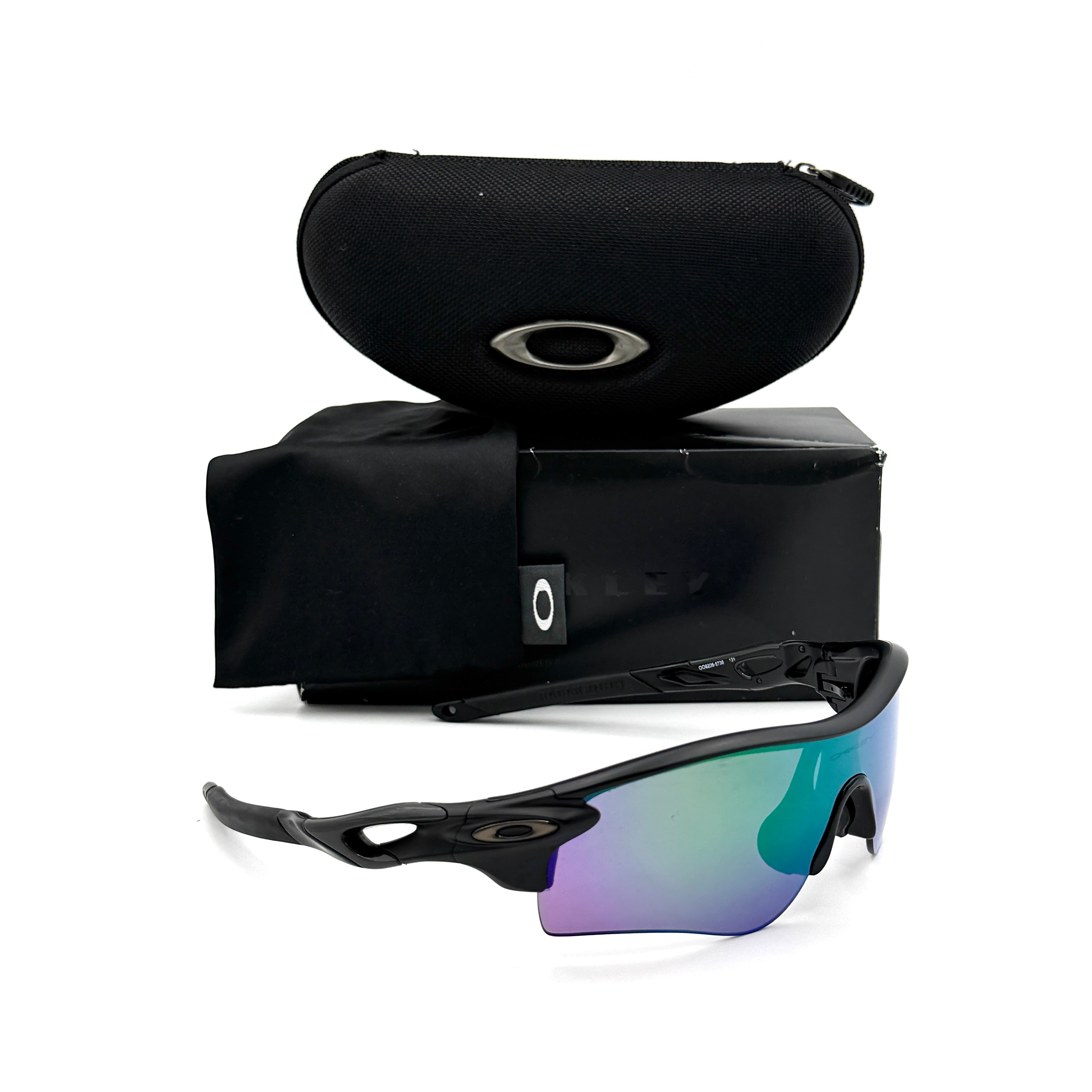 Oakley RadarLock Path sunglasses in matte black with reflective green and violet Prizm shield lens, presented with original black case, box, and cloth.