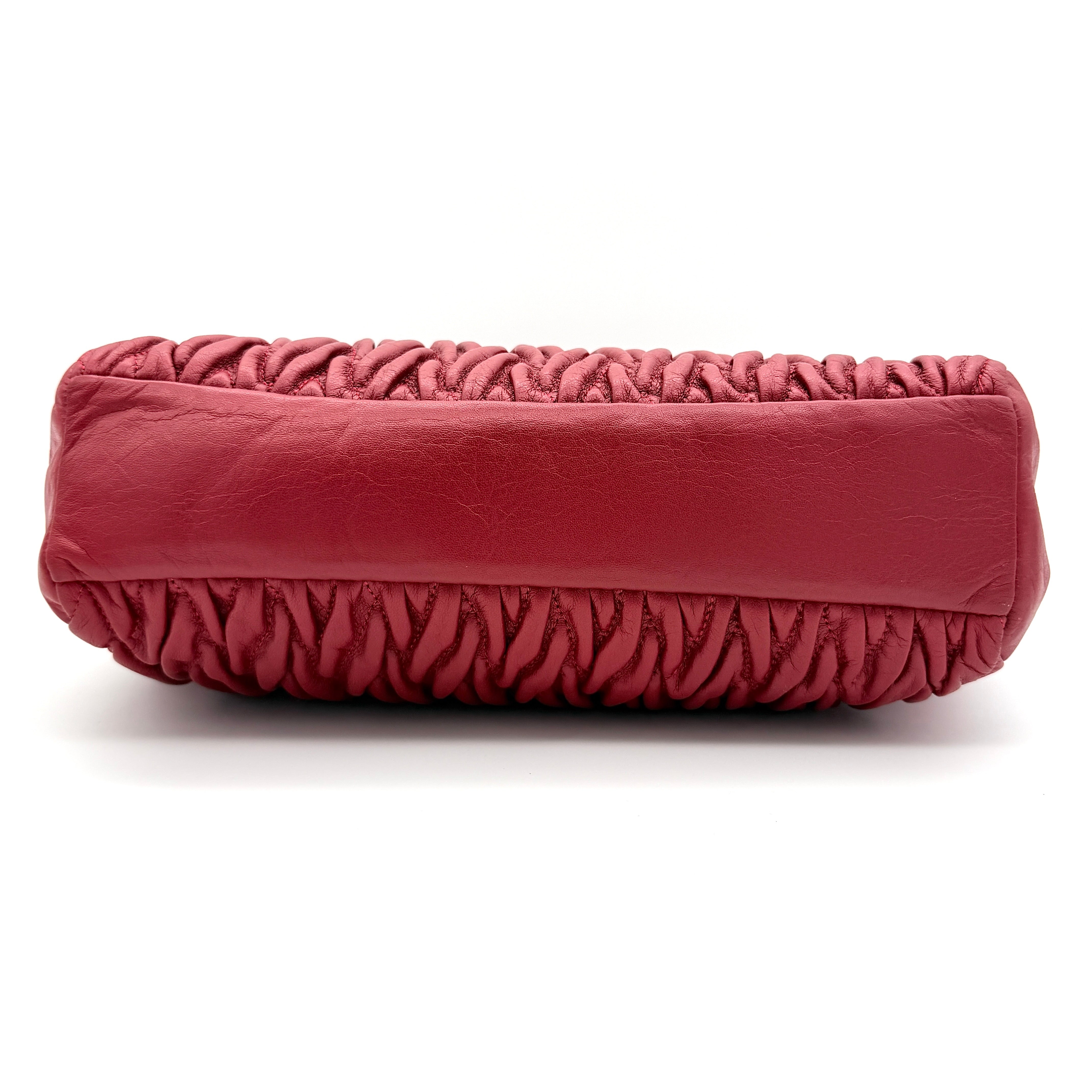 Coach Kelsey 2Way satchel in quilted red leather with gold-tone hardware and detachable strap, displayed against a white background.