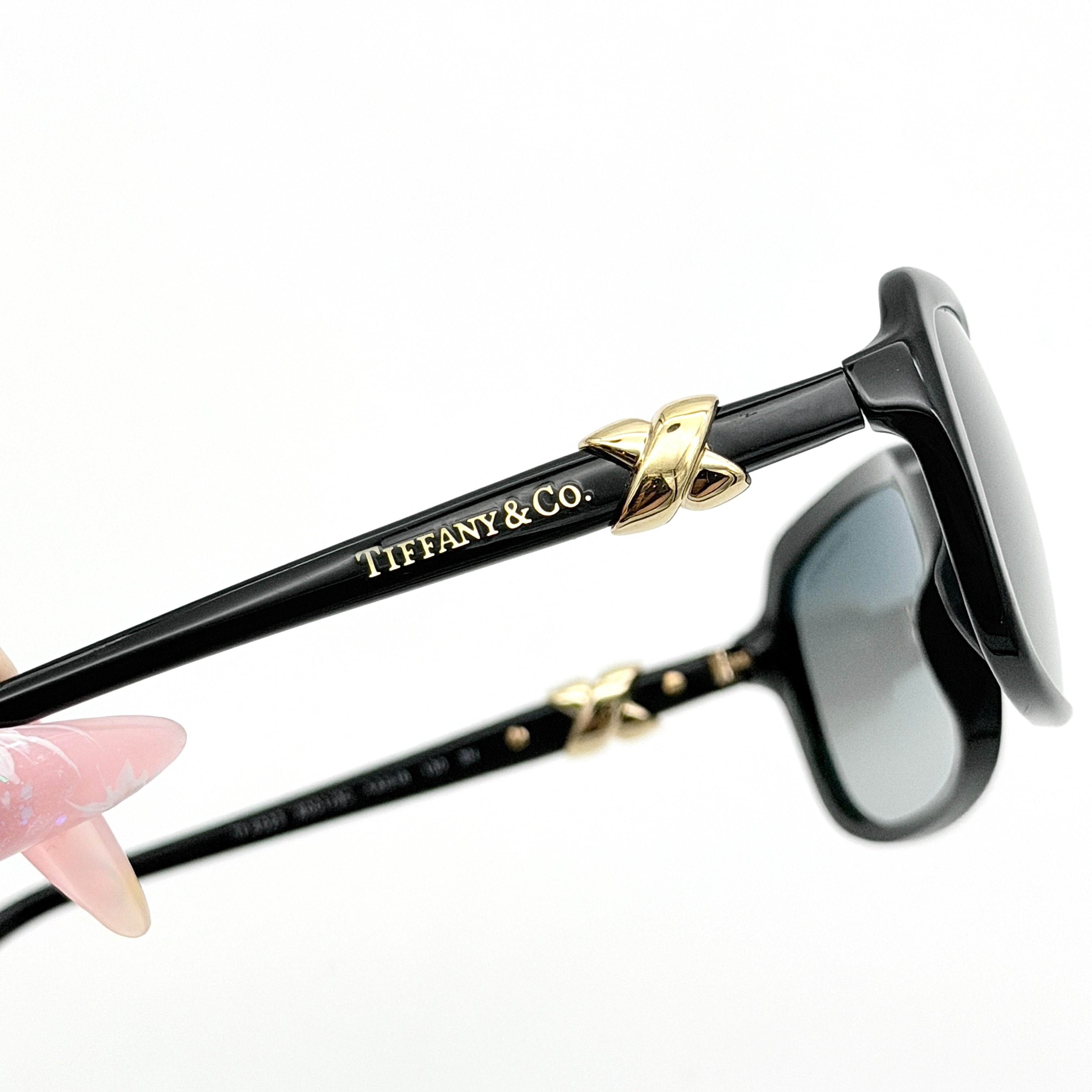 Tiffany & Co. TF4023 sunglasses in black with gold hardware, displayed with original turquoise case and accessories.