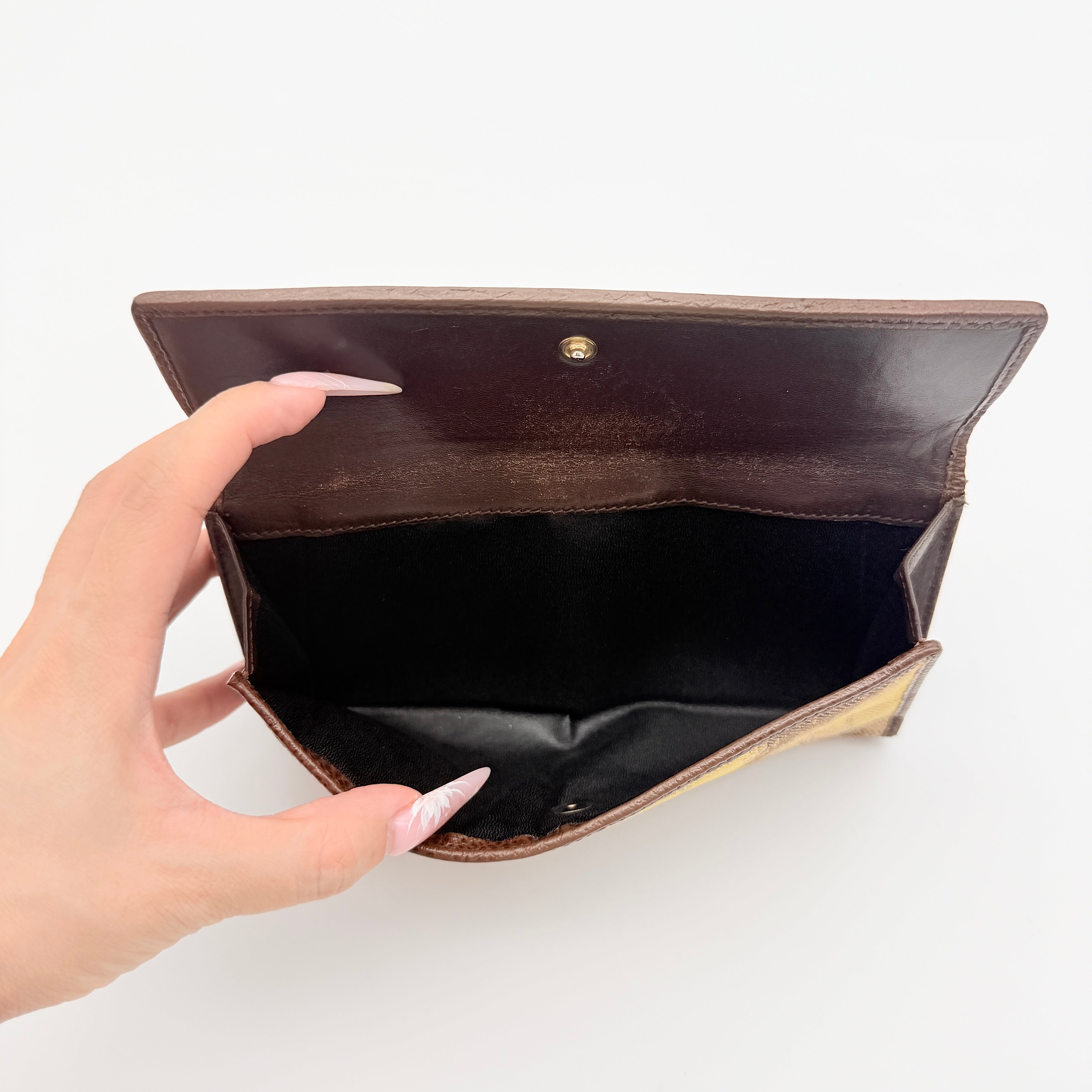Vivienne Westwood Orb long wallet in beige and brown canvas with the signature Orb logo and leather trim, photographed on a white background.