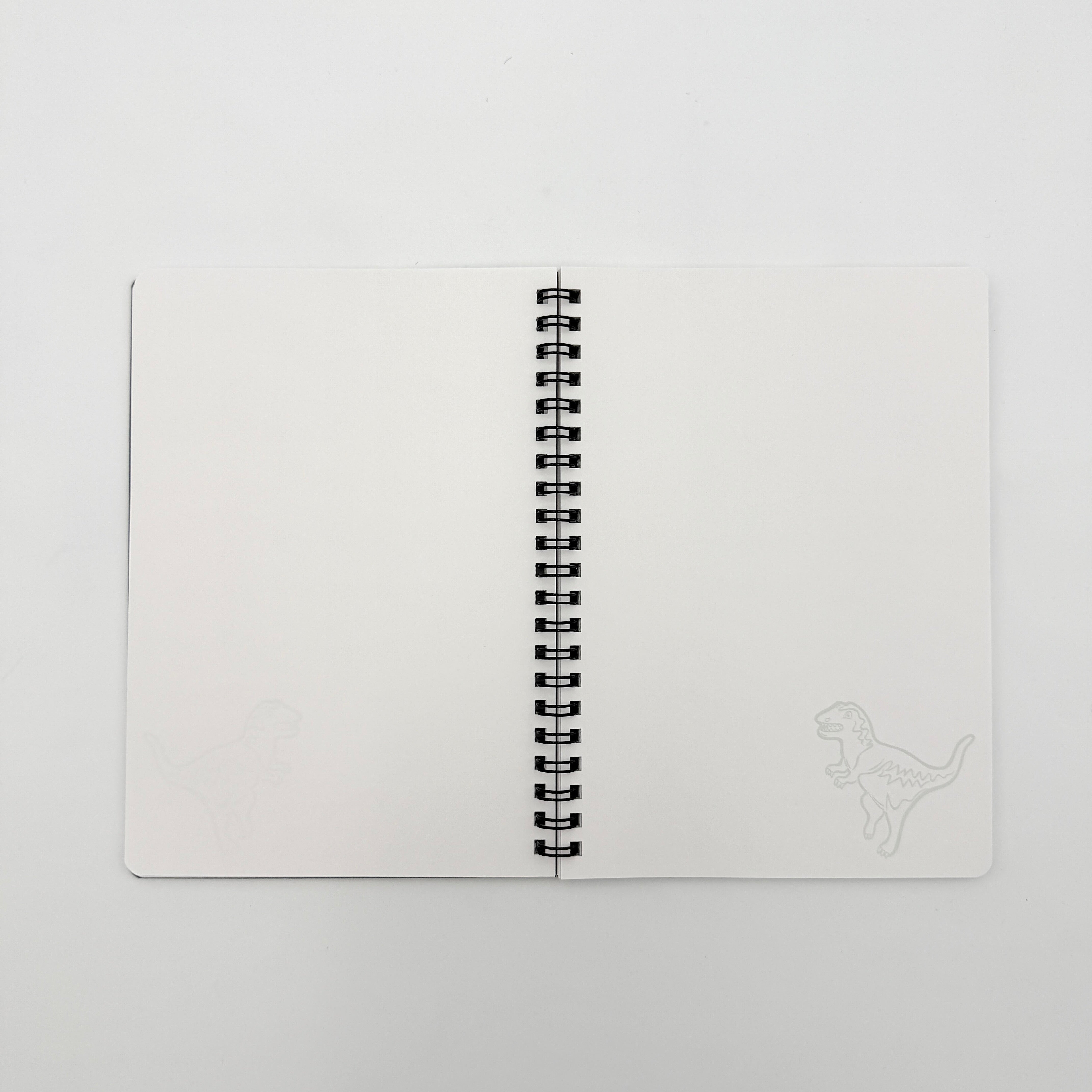 Coach Rexy Journal Notebook in black featuring white Rexy dinosaur illustrations and a spiral binding.
