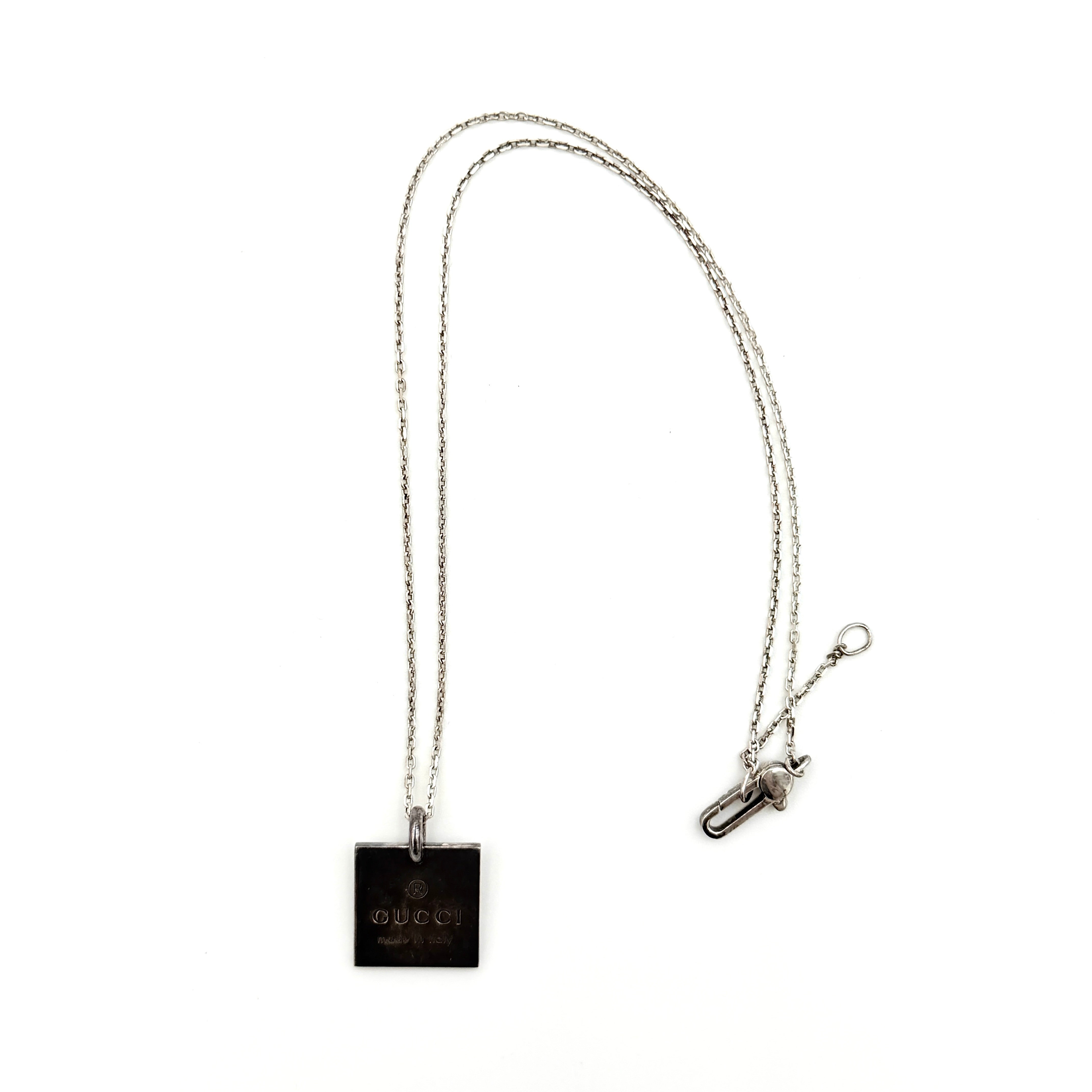 Gucci Trademark Square Plate Necklace in 925 silver with an engraved pendant and fine chain, artfully displayed against a clean background.