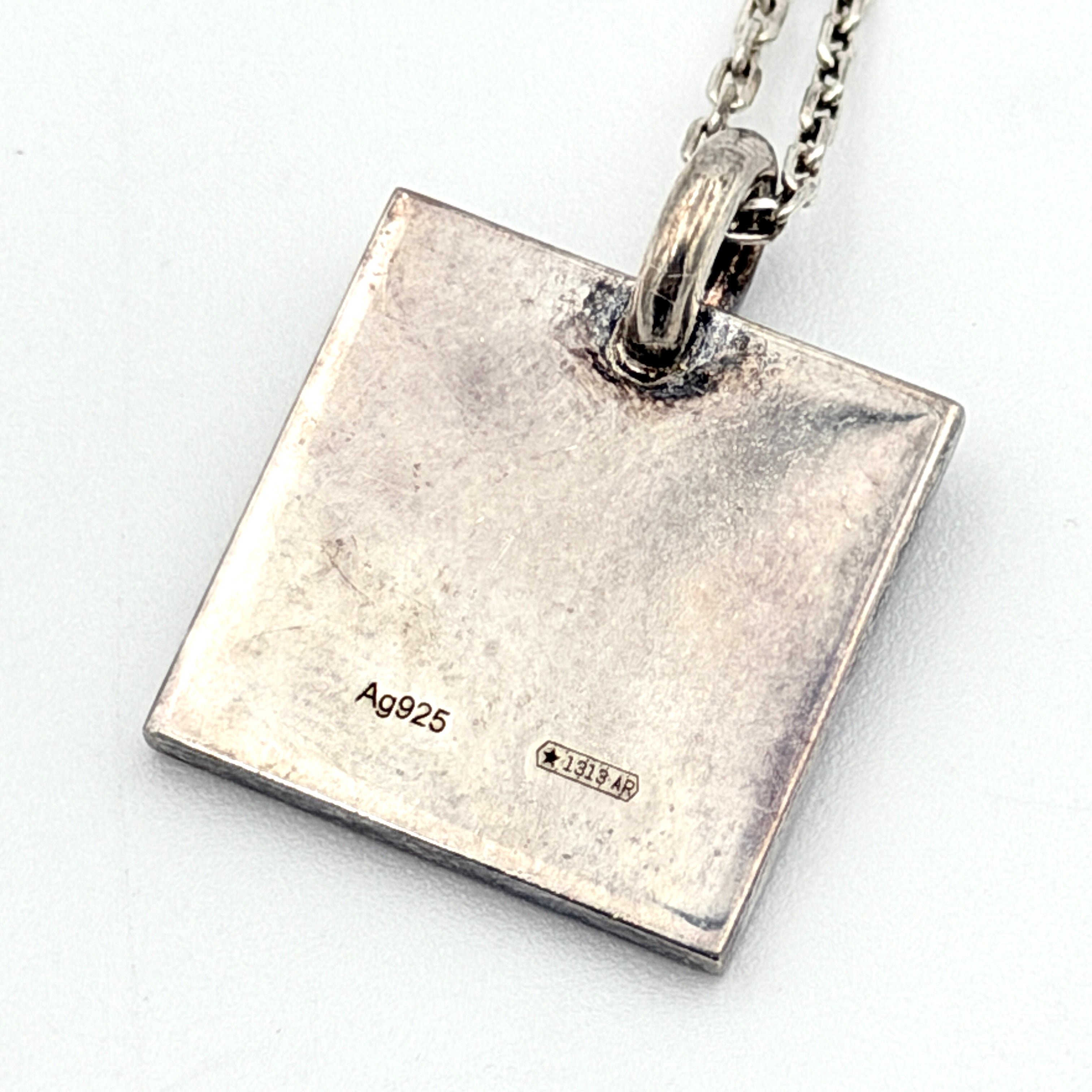 Gucci Trademark Square Plate Necklace in 925 silver with an engraved pendant and fine chain, artfully displayed against a clean background.