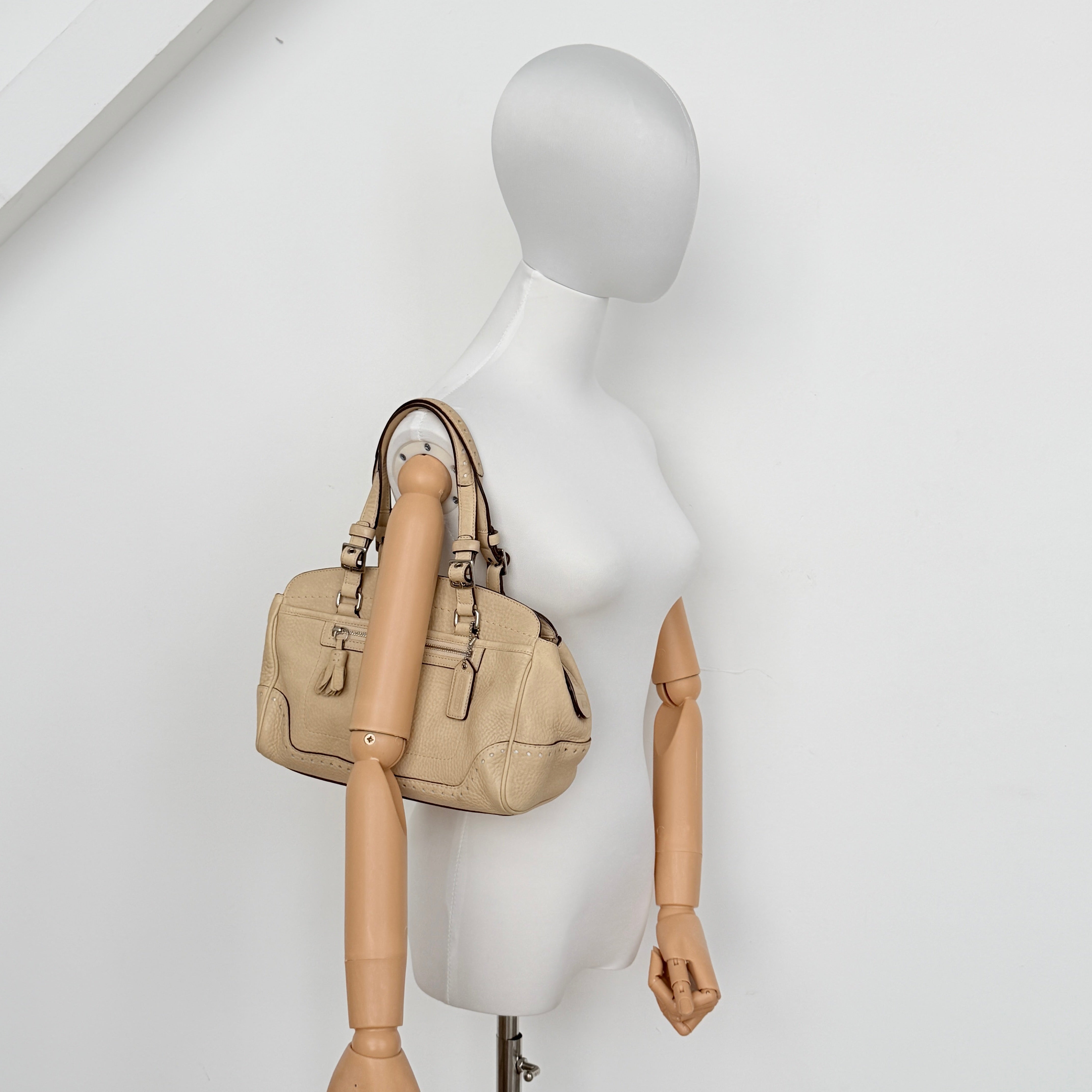 Coach Hampton Sand Satchel in beige pebbled leather with structured dual handles, front zip pocket, and silver-tone hardware.