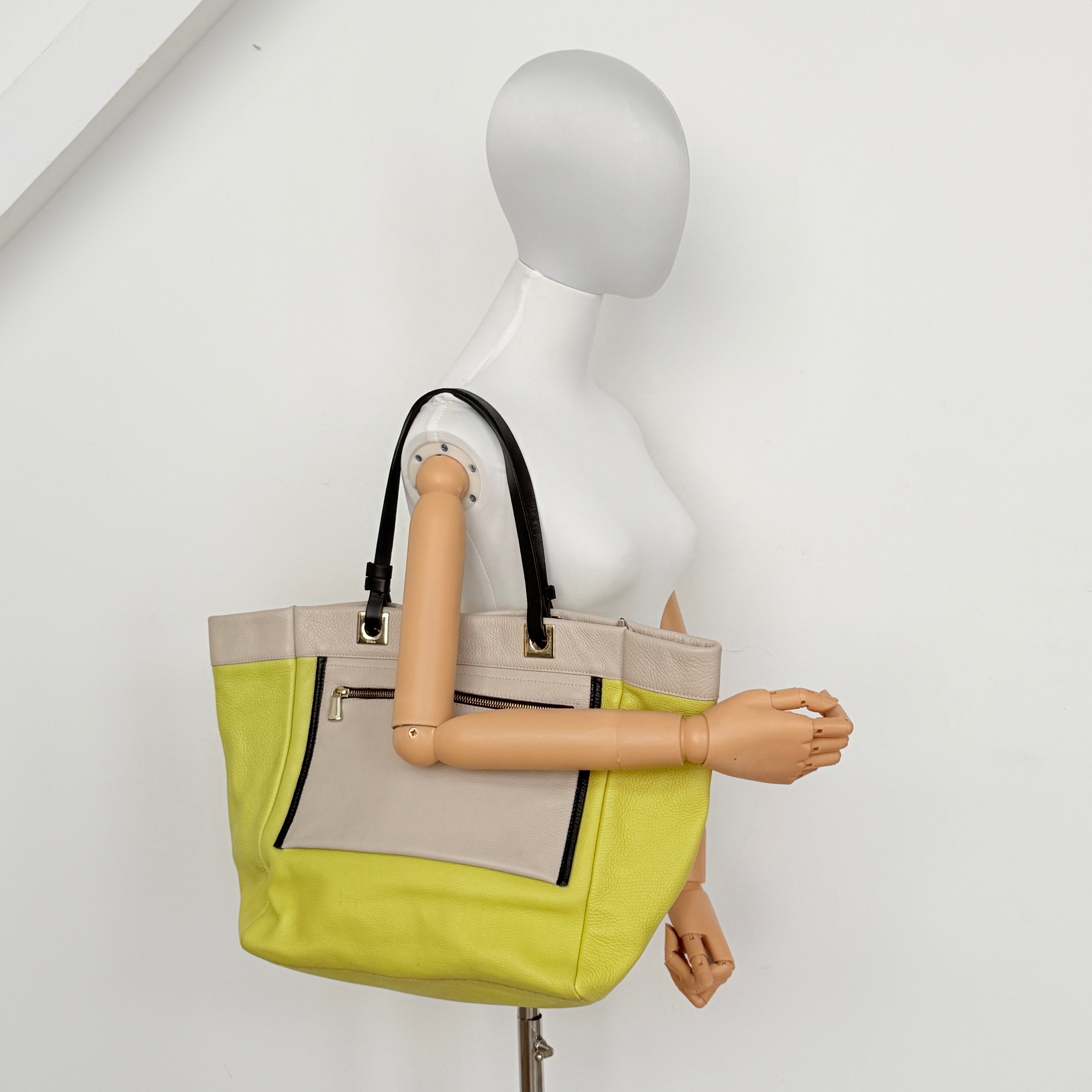 Furla Shopper Tote in neon yellow and beige grained leather with black handles and gold-tone hardware.