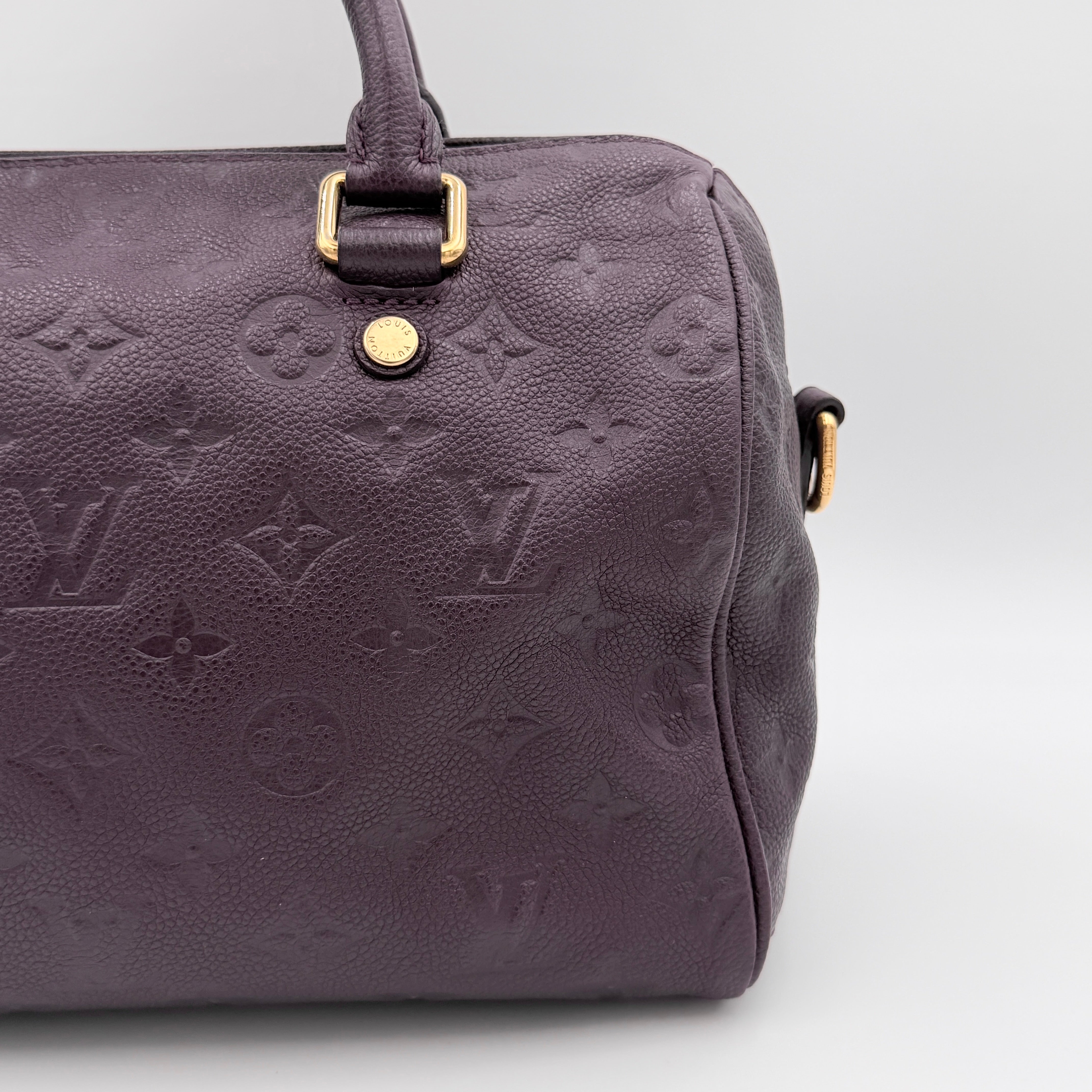 Louis Vuitton 2Way Monogram Empreinte Speedy Bandoulière 25 in deep purple grained leather with gold-tone hardware and detachable strap.