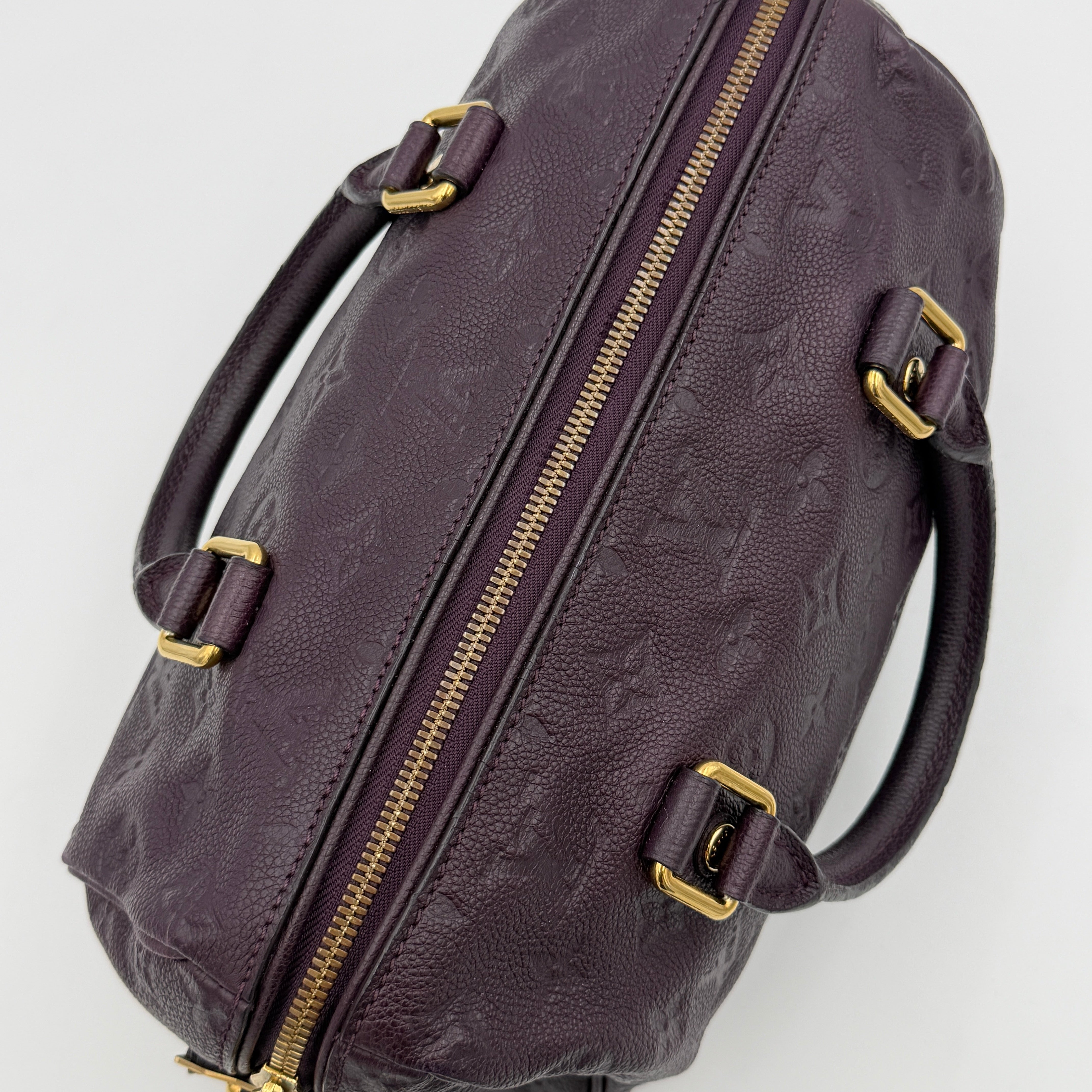 Louis Vuitton 2Way Monogram Empreinte Speedy Bandoulière 25 in deep purple grained leather with gold-tone hardware and detachable strap.