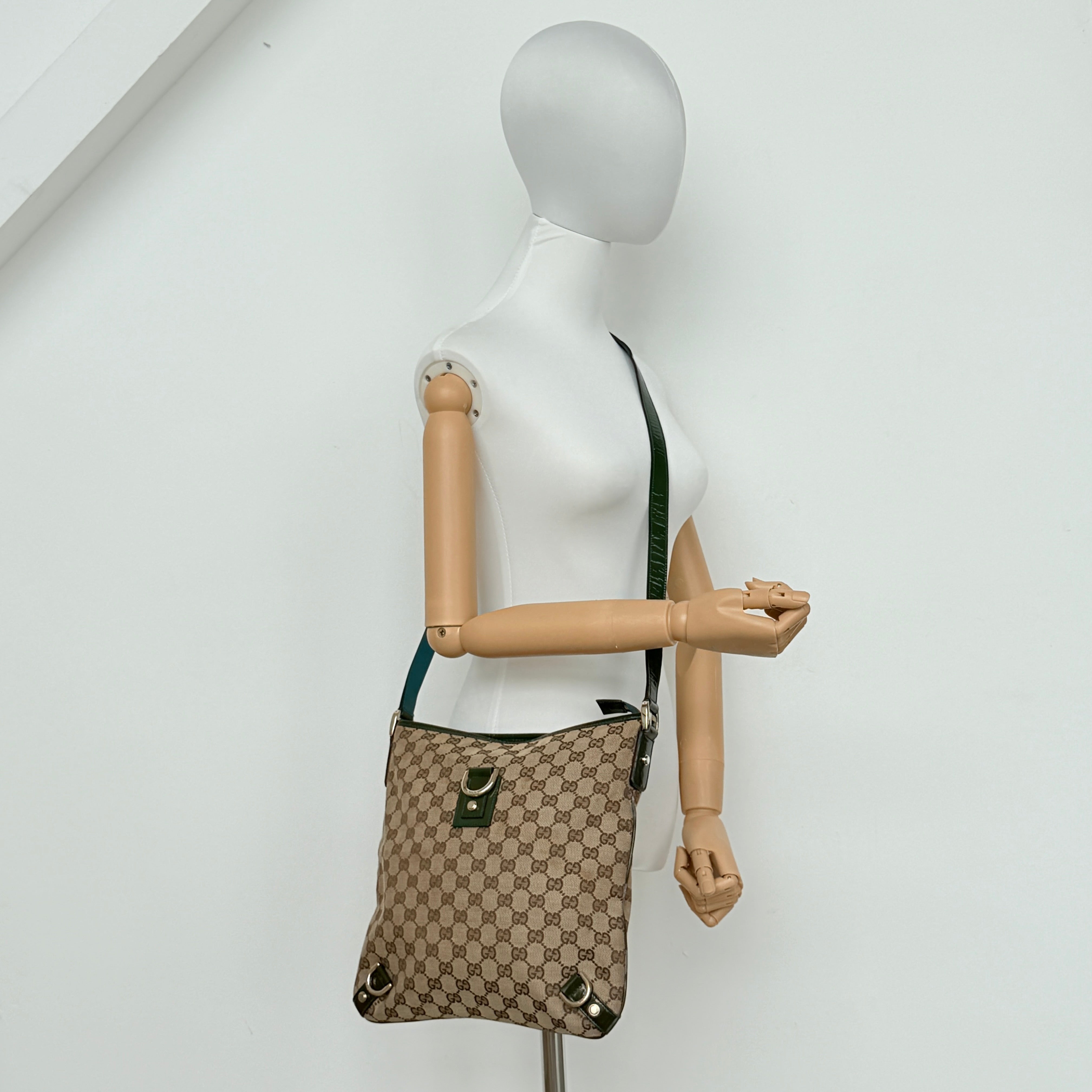 Gucci GG Monogram Abbey D Ring Crossbody Bag in beige canvas with green leather trim and gold-tone hardware, featuring an adjustable green strap.